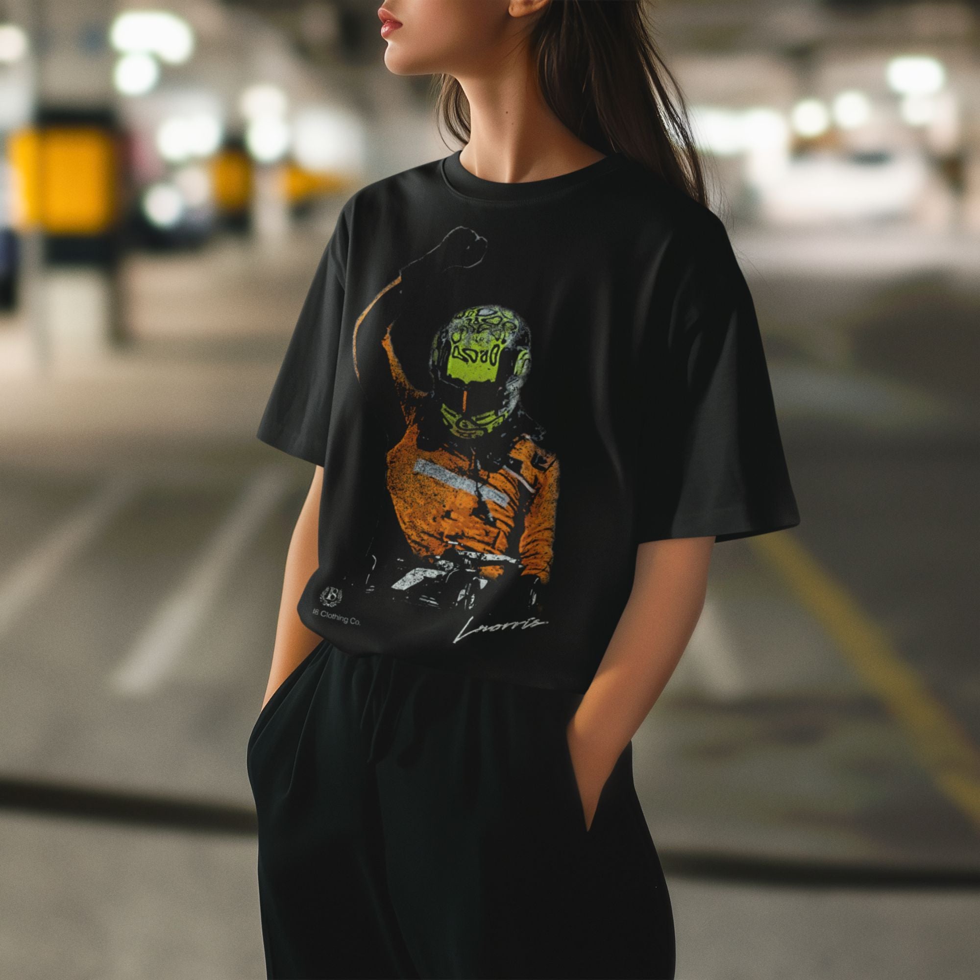 Person wearing a black t-shirt with a graphic design of a person in a helmet and racing suit.