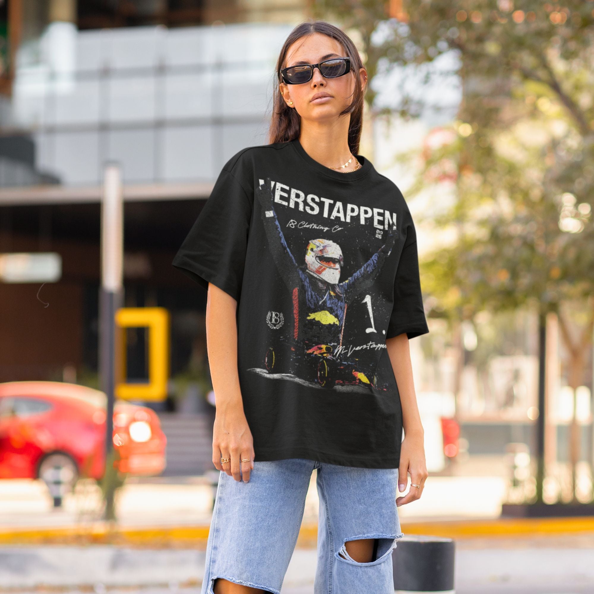 Woman wearing a black t-shirt with a graphic design on a city street.
