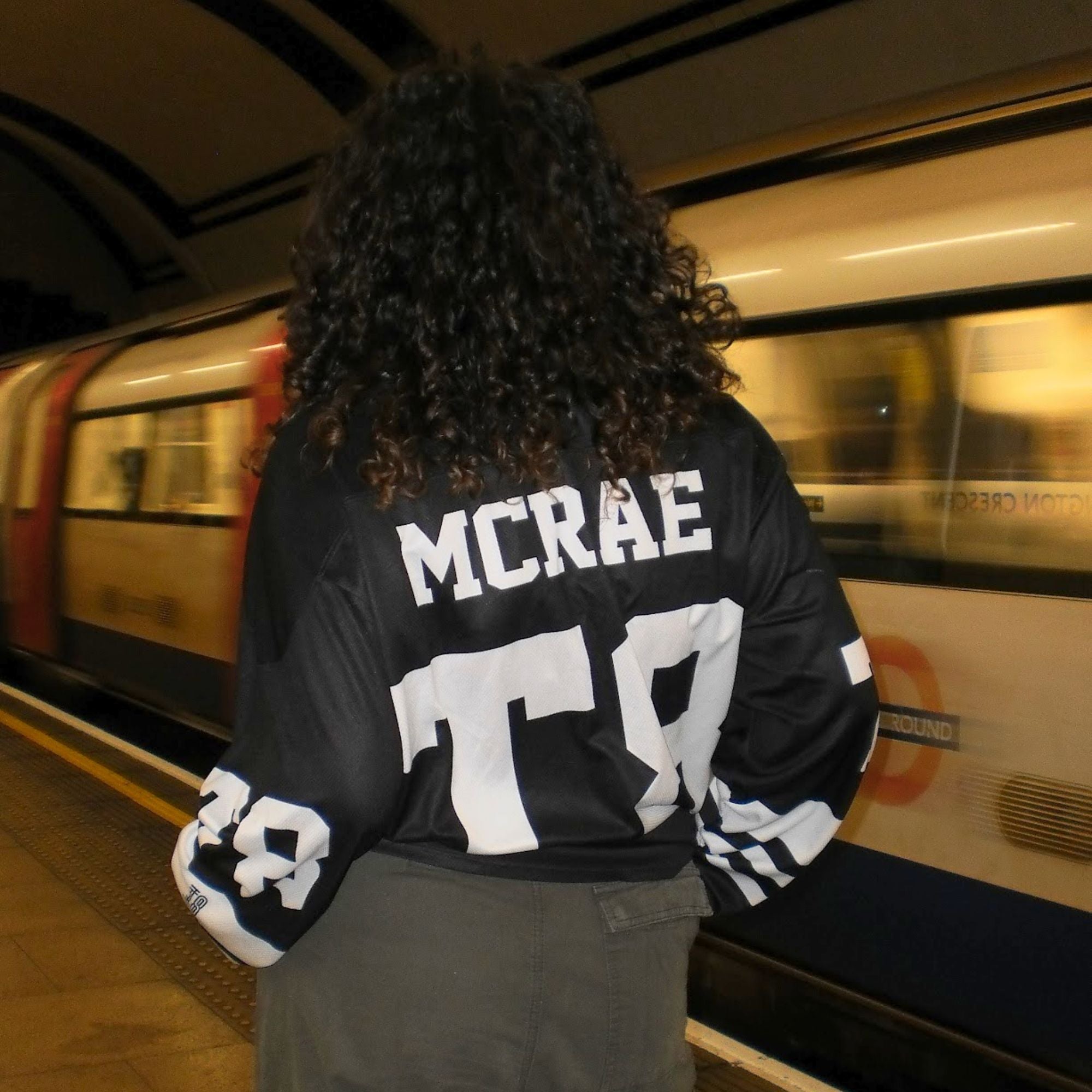 A black and white hockey jersey with the name Mcrae in white on the front and back. Also T8 in white on the front and back.