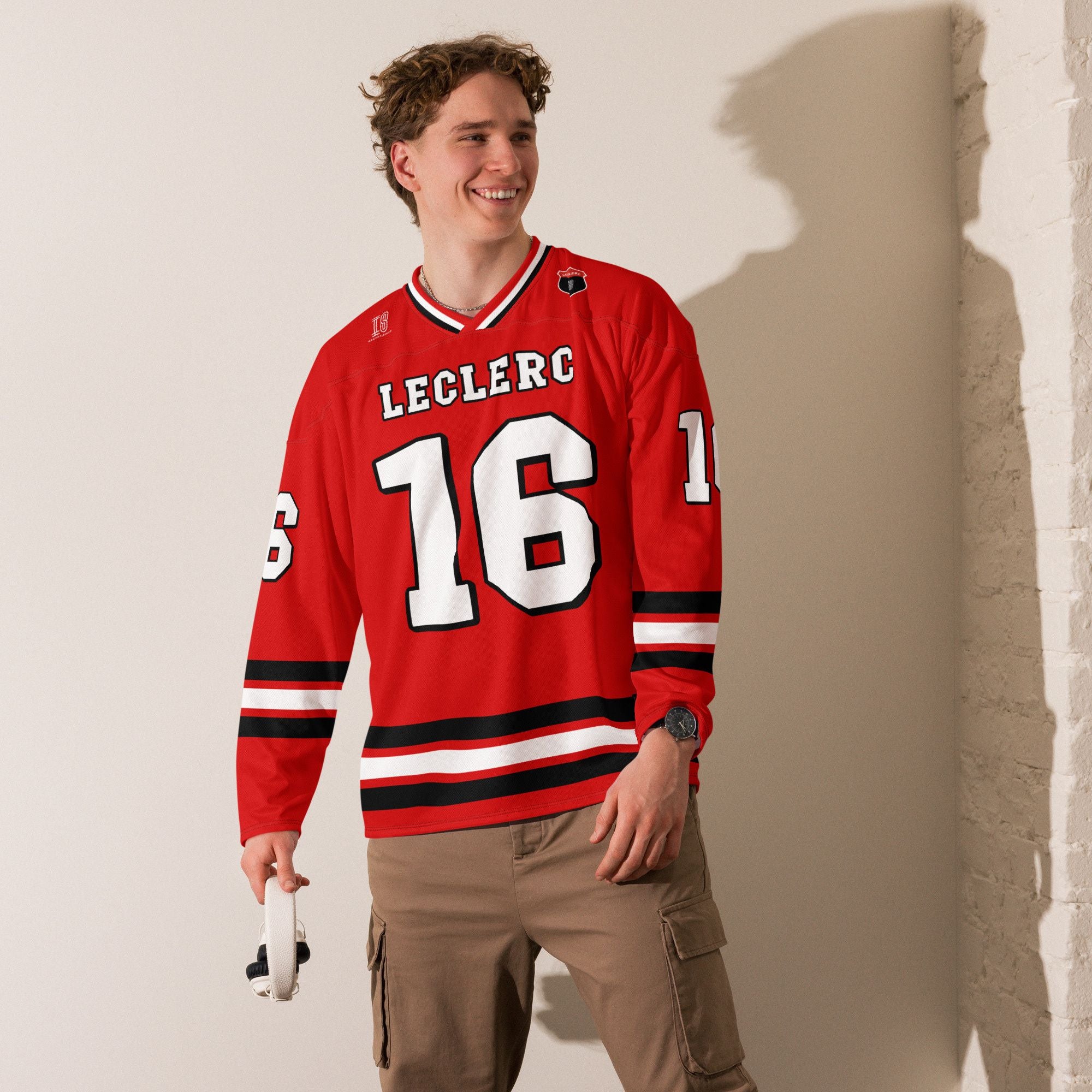 A Ferrari red hockey jersey with charles lecerc's f1 racing number 16 on the front in back, colored in black.