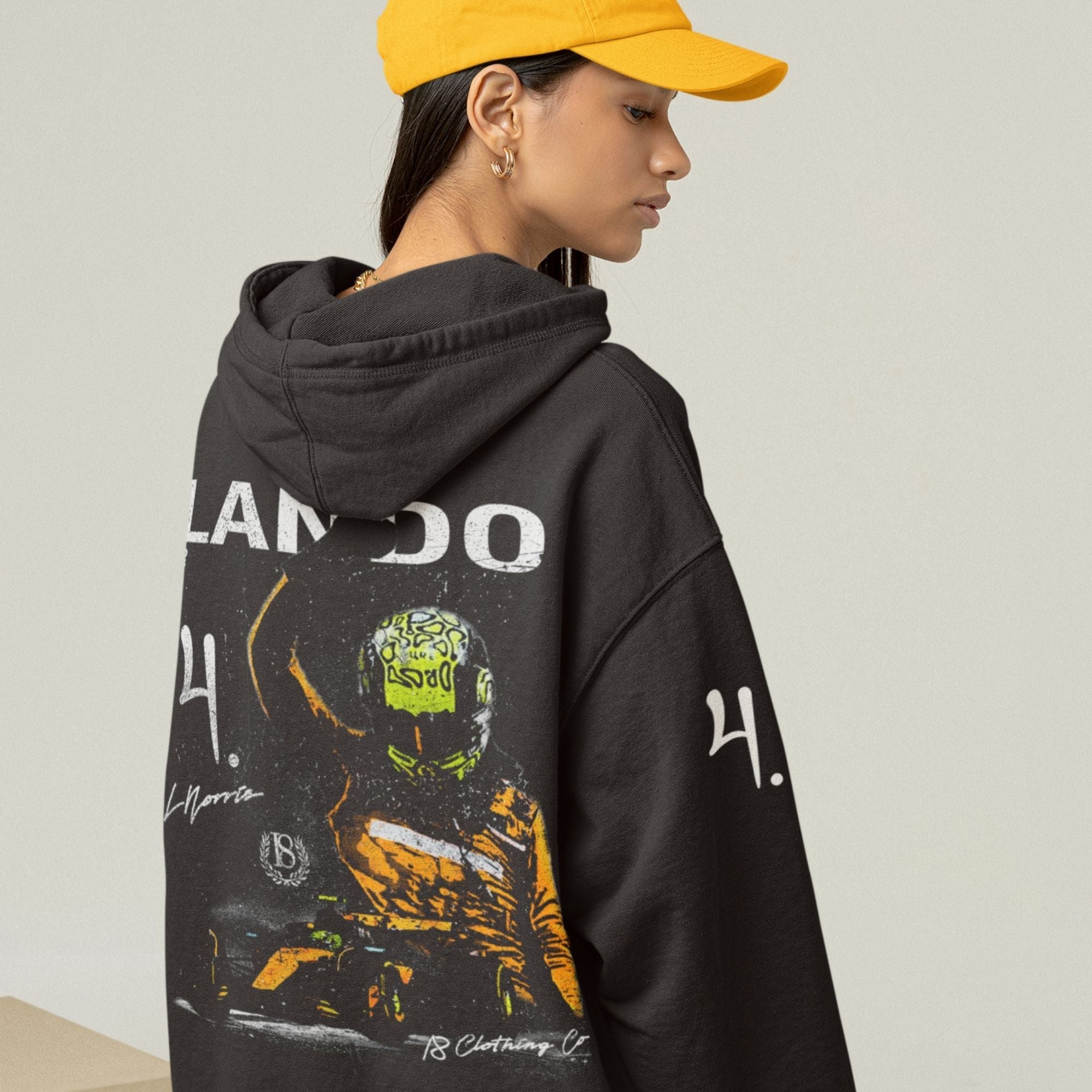 Person wearing a black hoodie with graphic design and text, standing against a plain background