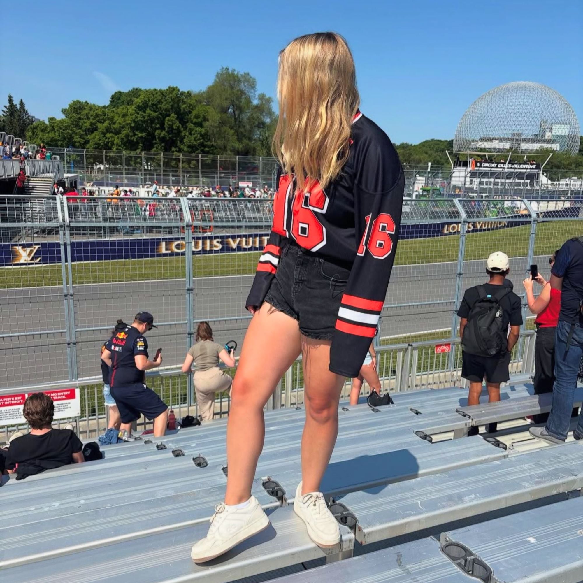 A black hockey jersey with red and white stripes on the bottom and the arms. It has Charles Leclerc's Ferrari F1 racing number 16 on the front and the back with the name Leclerc just above each number