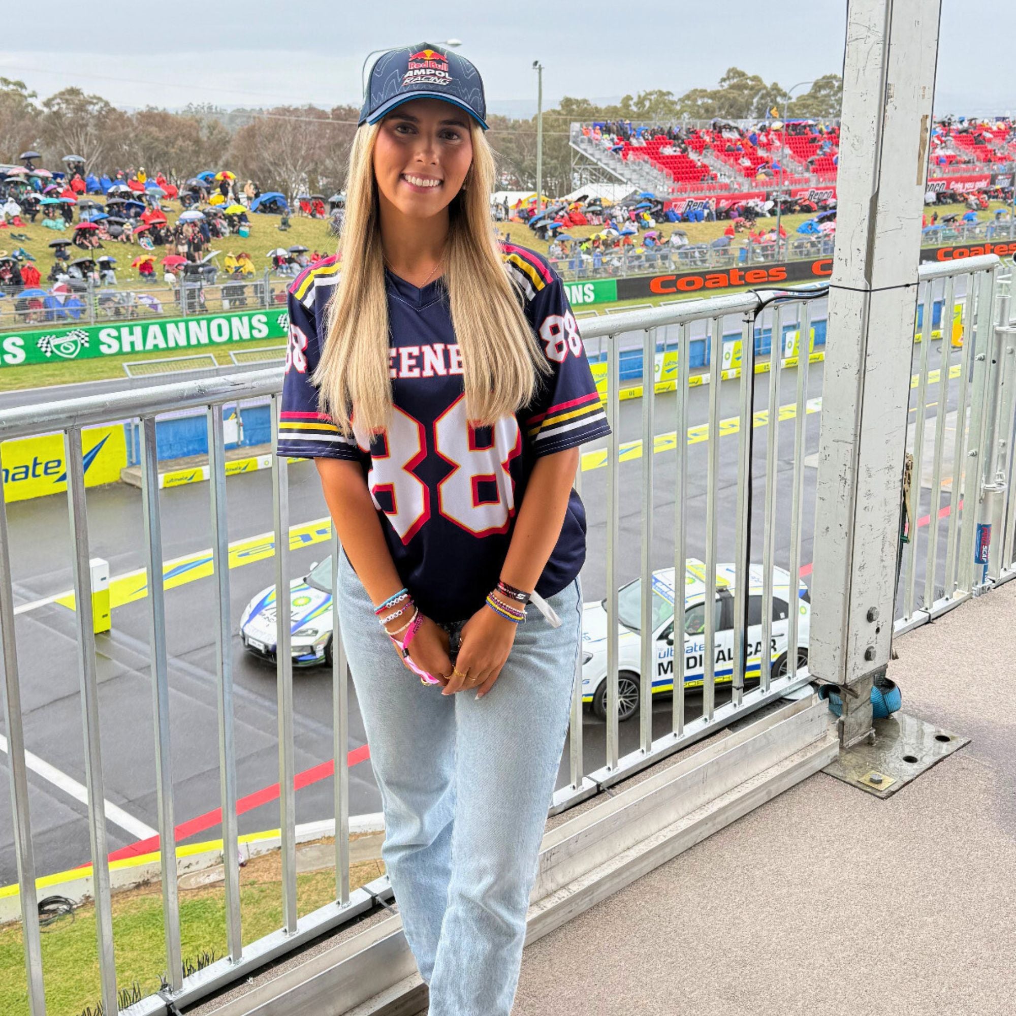 Woman in a sports jersey and cap at a race track event