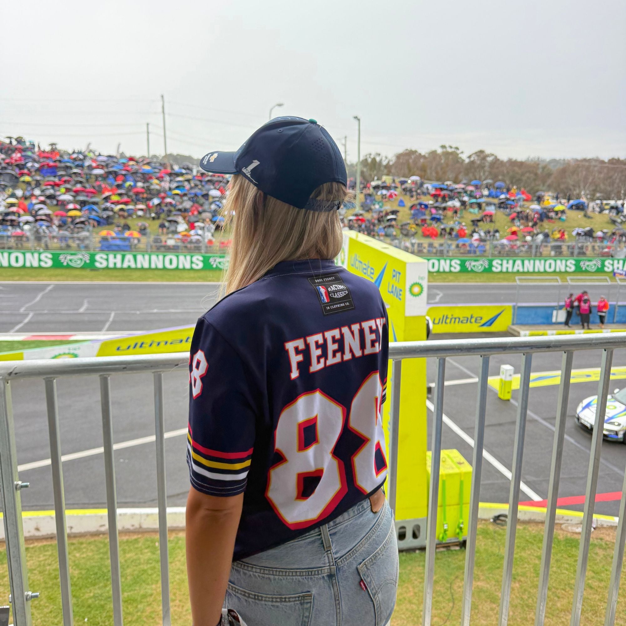 Person wearing a sports jersey with 'FEENES' and number '88' at a race track event.