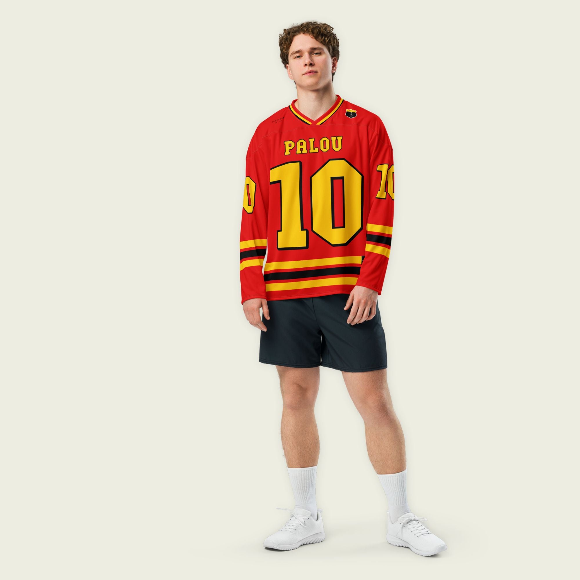 A red hockey jersey with Alex Palou's indycar racing number 10 on the front and back in yellow, also the name palou is on the back and front in yellow.