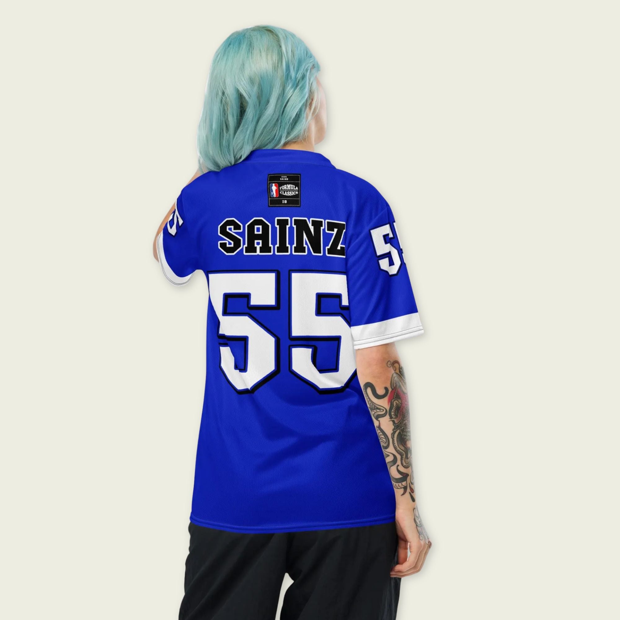 A blue and white football jersey with Carlos Sainz's Williams F1 racing number 55 on the back and front in white. It has the name sainz in white on the front and back as well.
