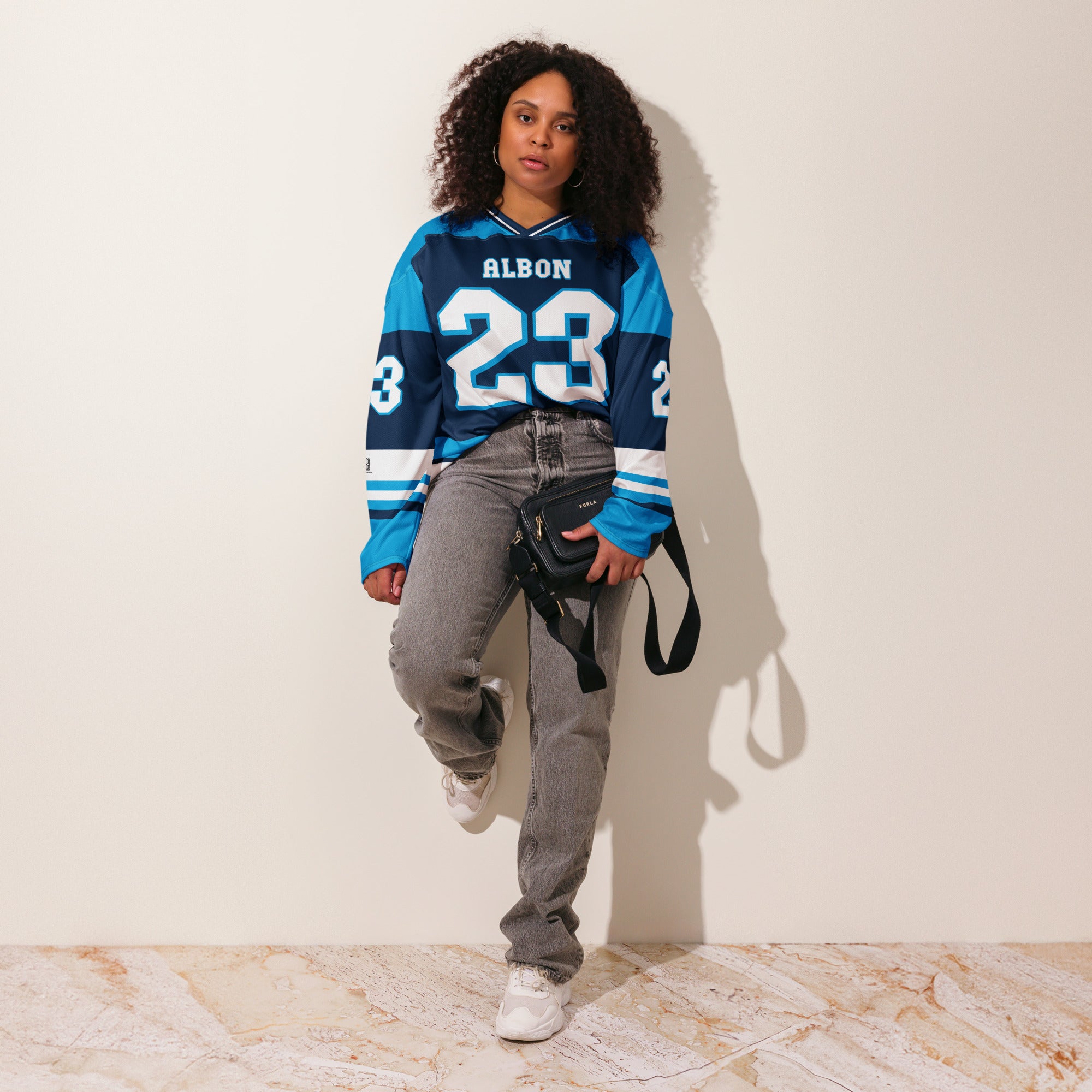 A blue hockey jersey with Alex Albon's Williams F1 racing number 23 on the front and back in white, also the name Albon is on the back and front in White.