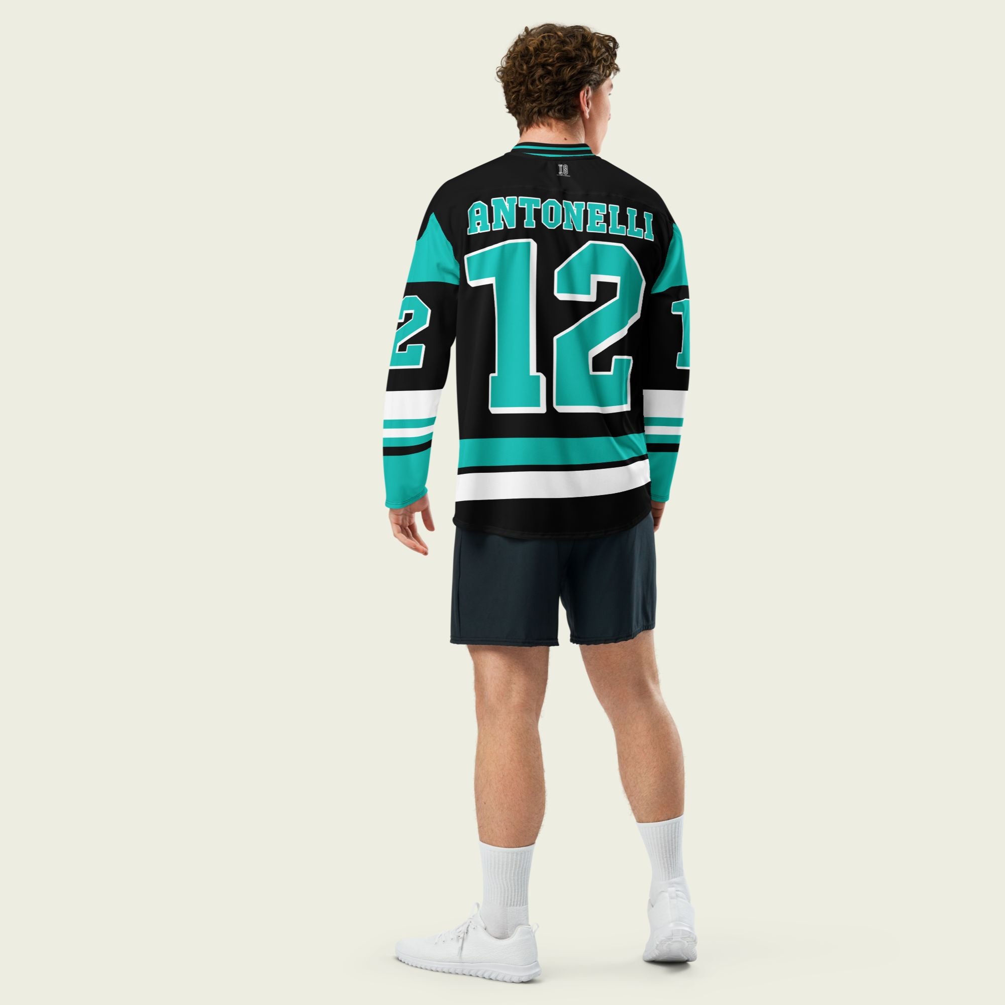 A black and turquoise hockey jersey with Andrea Kimi Antonelli's Mercedes F1 racing number 12 in turquoise on the front and back. It has the name Antonelli on the back and front in turquoise as well.