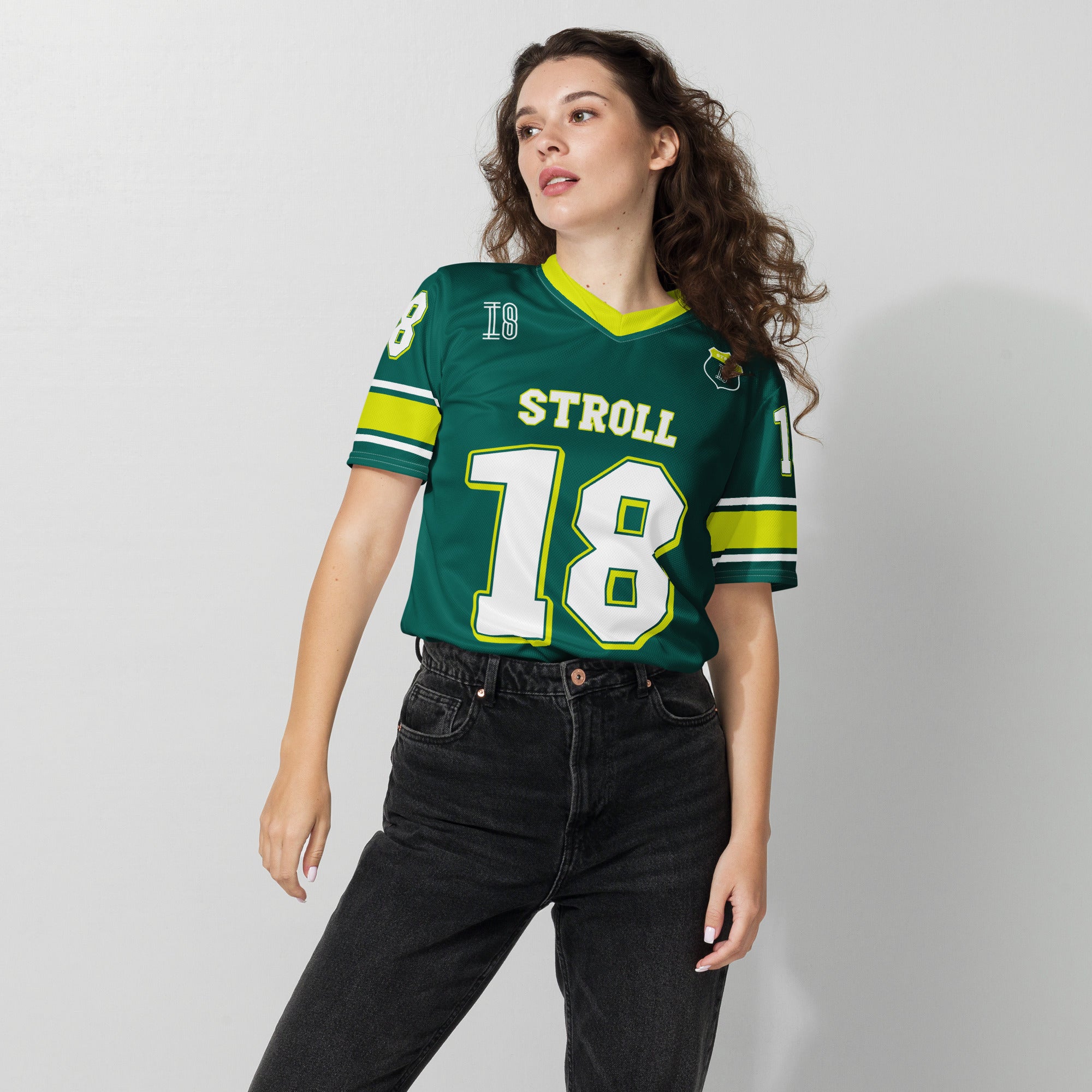 A british green and highlight yellow football jersey with Lance Stroll's Aston Martin F1 racing number 18 on the front and back. It has the name Stroll on the front and back as well in white with a yellow outline.