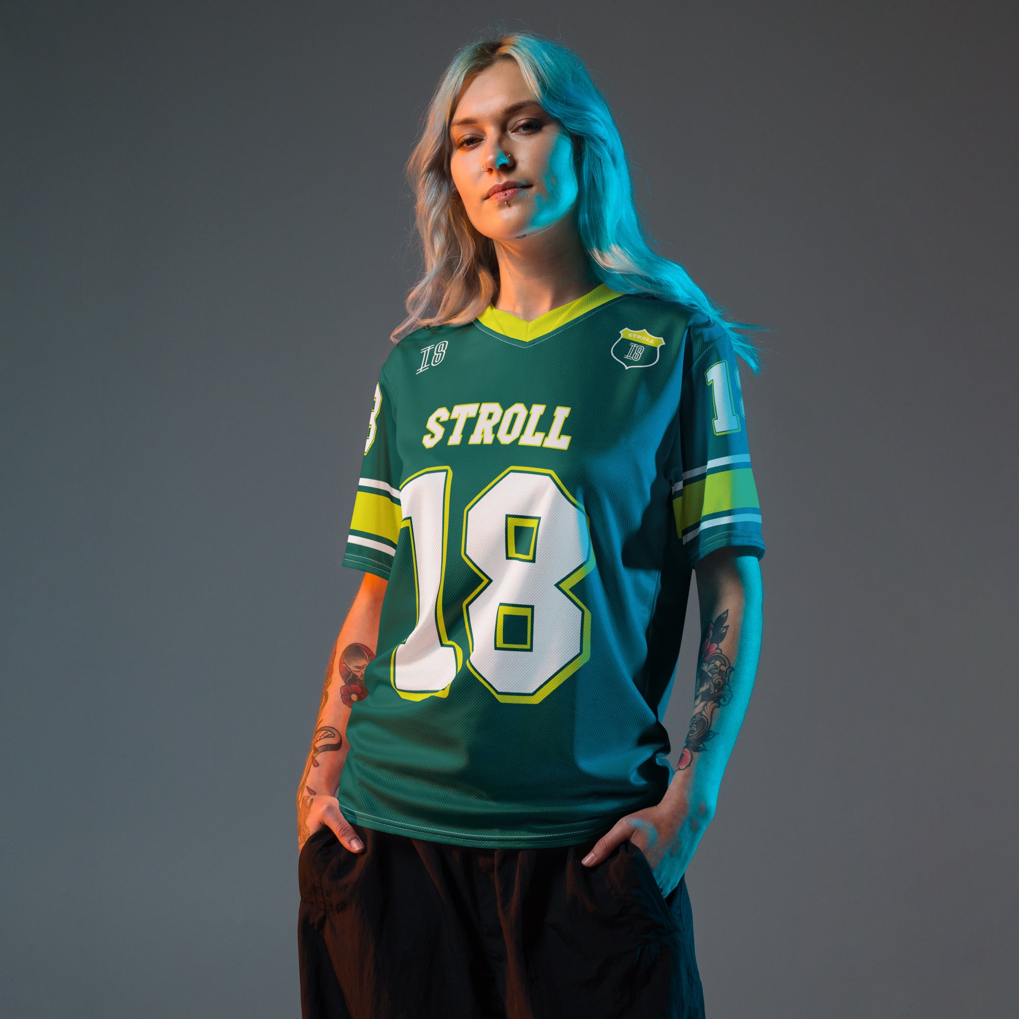 A british green and highlight yellow football jersey with Lance Stroll's Aston Martin F1 racing number 18 on the front and back. It has the name Stroll on the front and back as well in white with a yellow outline.