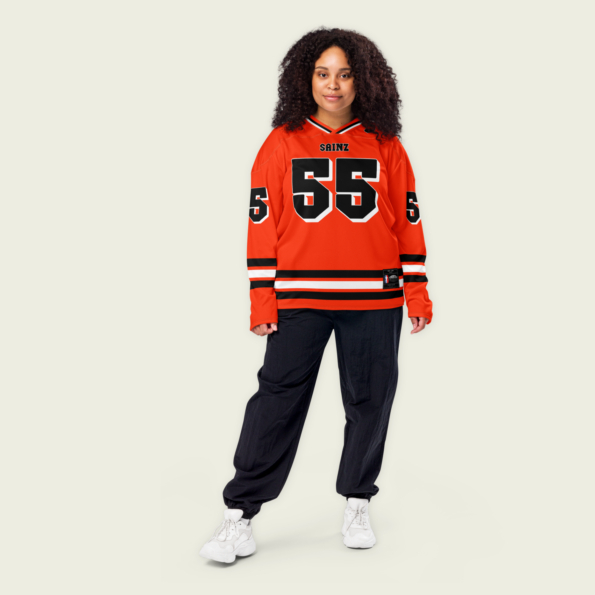 A red and black ferrari hockey jersey with Carlos Sainz Jnr's f1 racing number 55 on the front and back and his name sainz on the back and front.