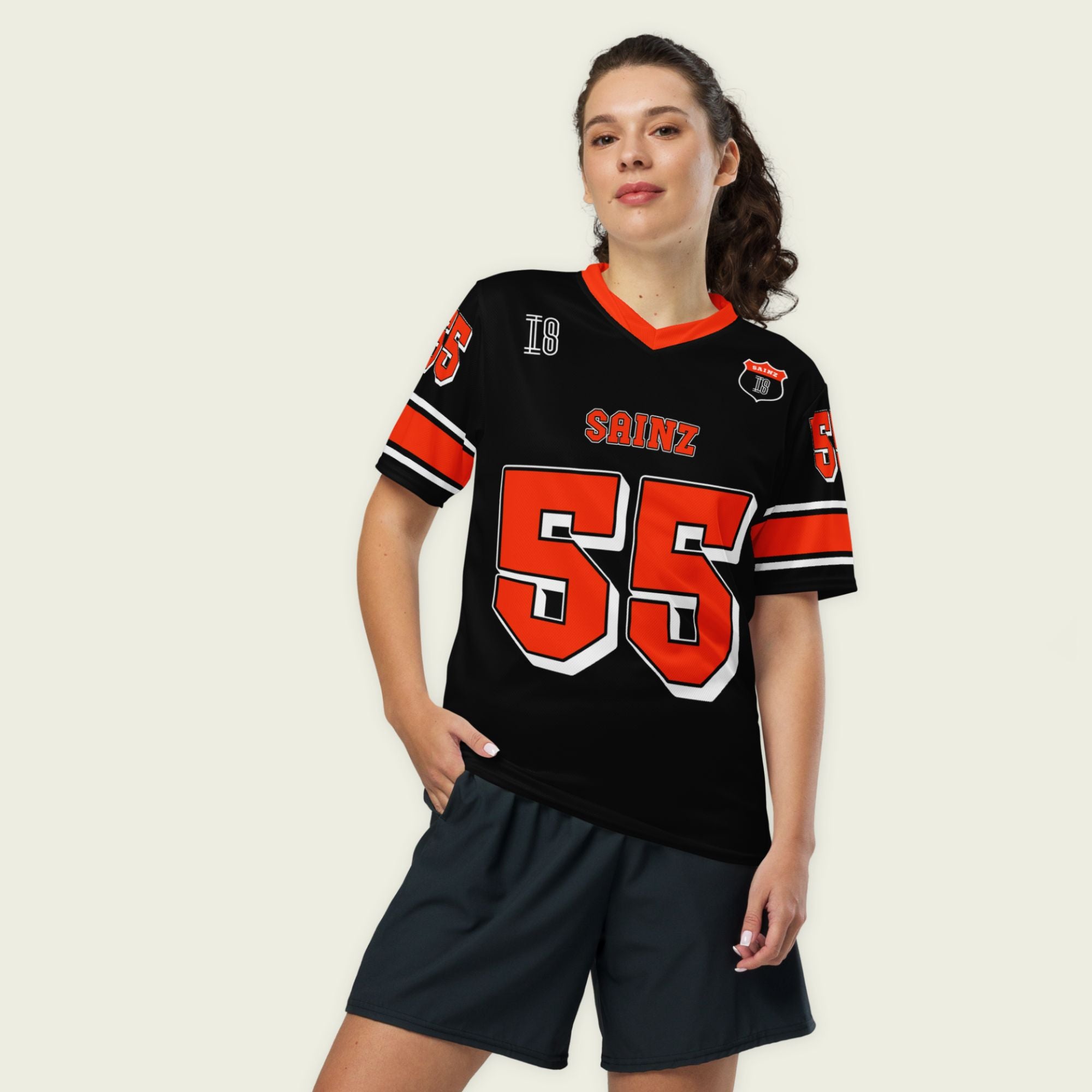 A black and red football jersey with Carlos Sainz Ferrari F1 racing number 55 in red. it has his name saizn on the front and back as well.
