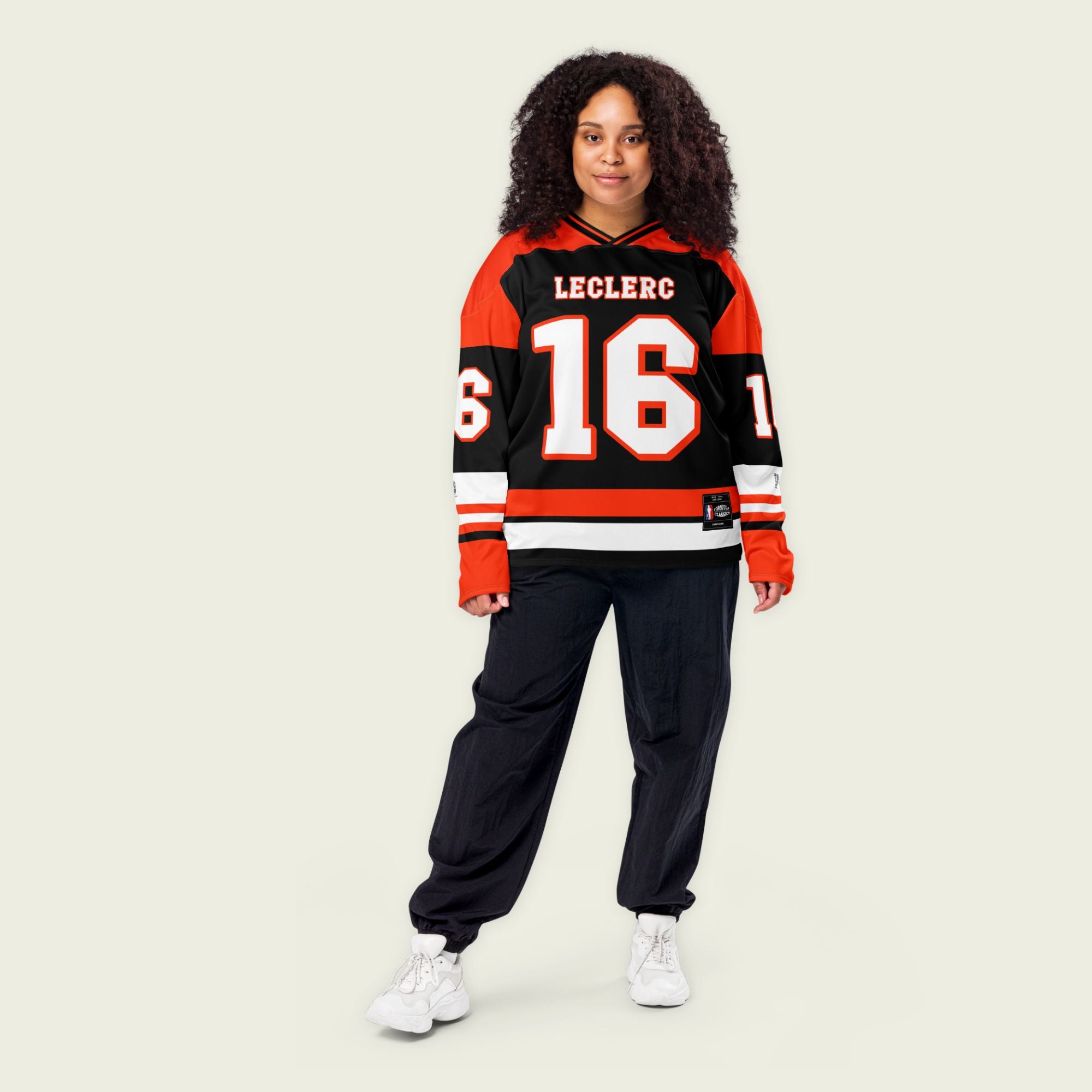 A red and black hockey jersey with Charles Leclerc's Ferrari F1 racing number 16 in white on the front and back. It has the name Leclerc on the back and front in white as well.