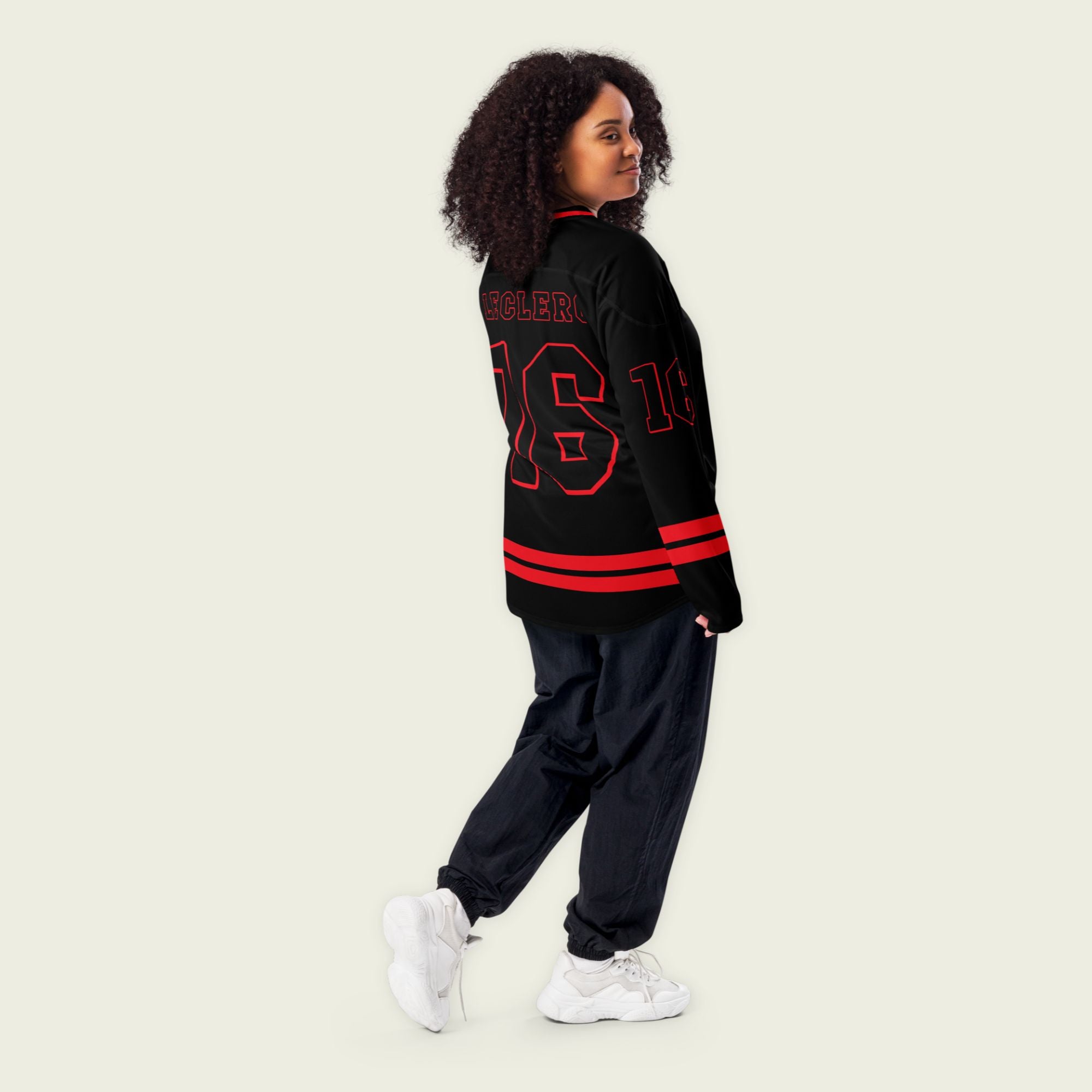 A black hockey jersey with red and white stripes on the bottom and the arms. It has Charles Leclerc's Ferrari F1 racing number 16 on the front and the back with the name Leclerc just above each number