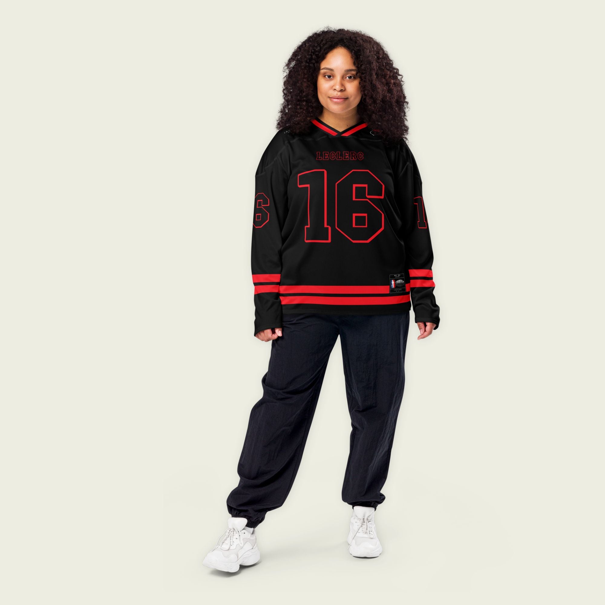 A black hockey jersey with red and white stripes on the bottom and the arms. It has Charles Leclerc's Ferrari F1 racing number 16 on the front and the back with the name Leclerc just above each number