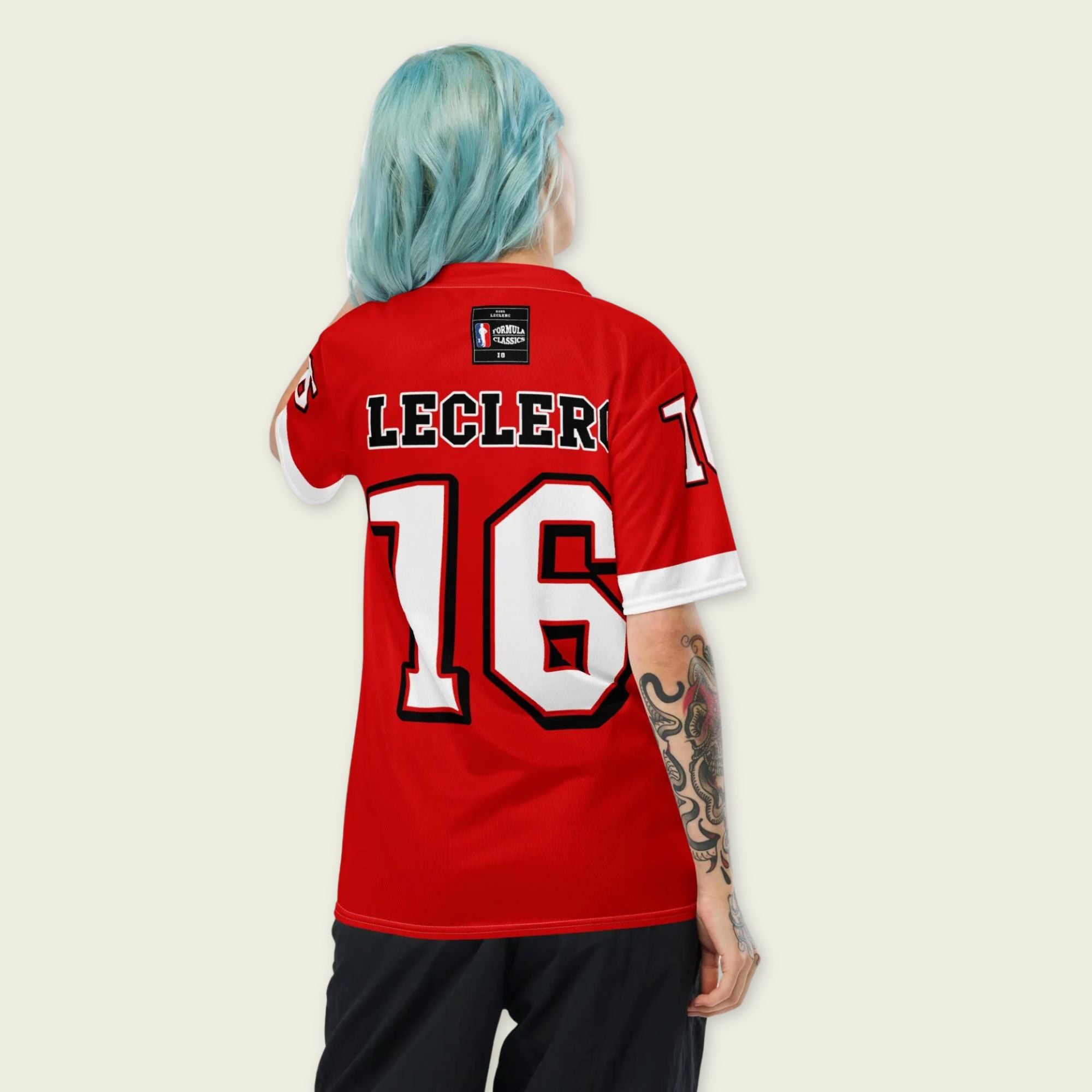 A red and white football jersey with Charles Leclerc's Ferrari  F1 racing number 16 on the back and front in white. It has the name Leclerc in black on the front and back as well.