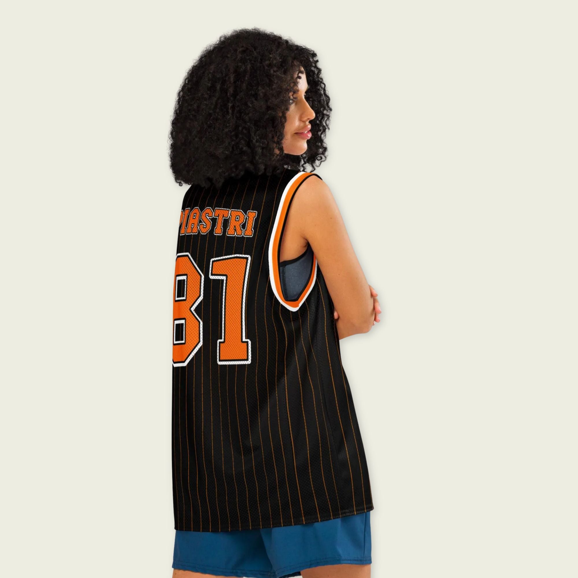 A black and papaya orange pin striped basketball Jersey with Oscar Piastri's McLaren F1 racing number 81 in orange on the front and back.