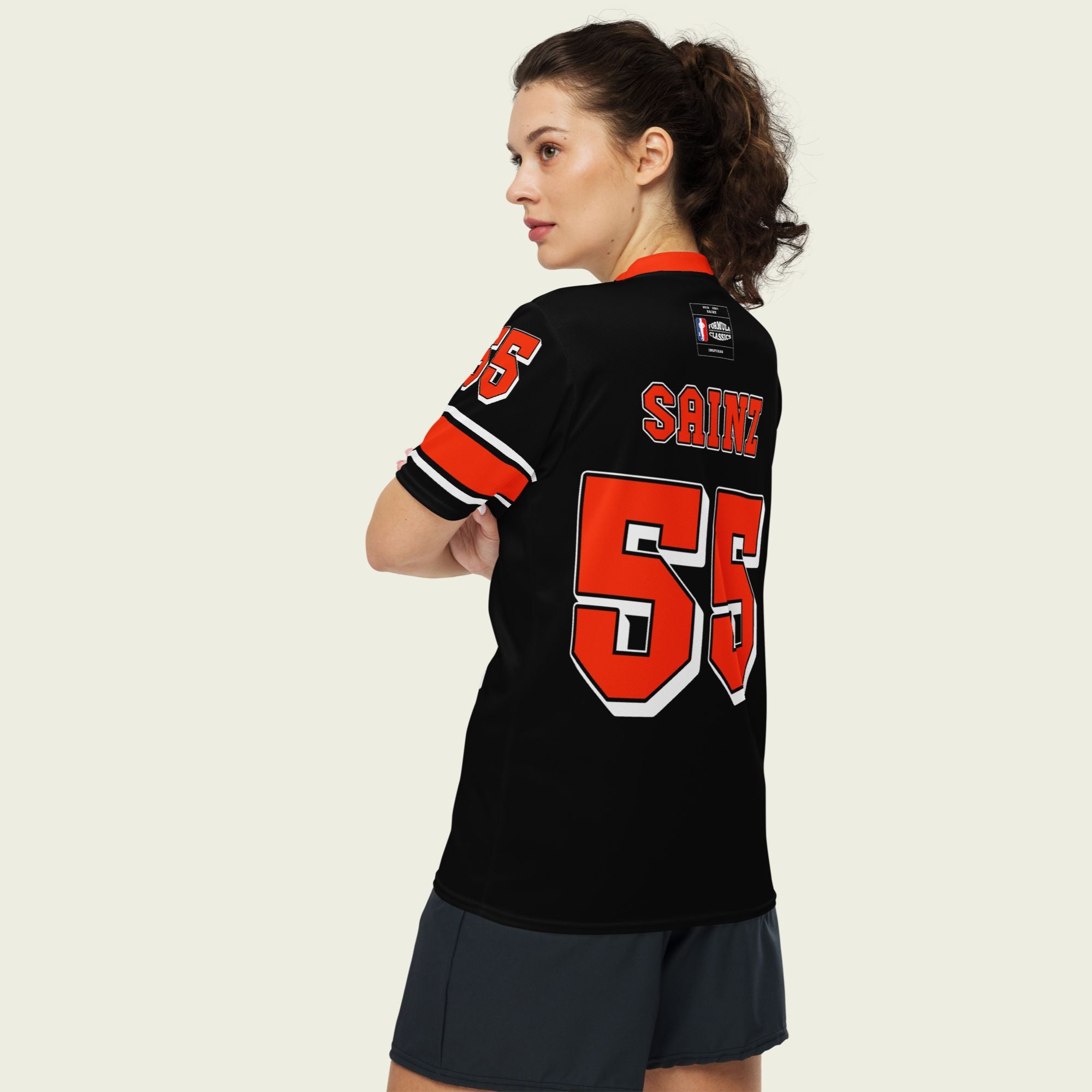 A black and red football jersey with Carlos Sainz Ferrari F1 racing number 55 in red. it has his name saizn on the front and back as well.