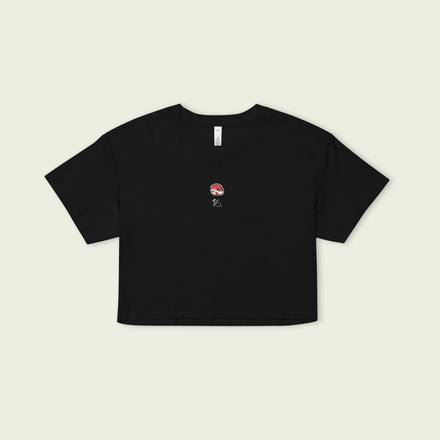 Black crop top with a small graphic on a beige background