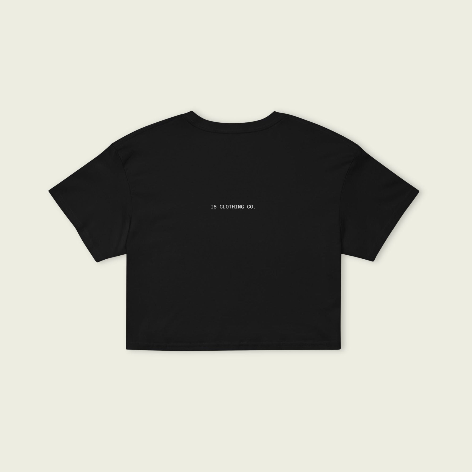 Black t-shirt with a small logo on the back against a beige background