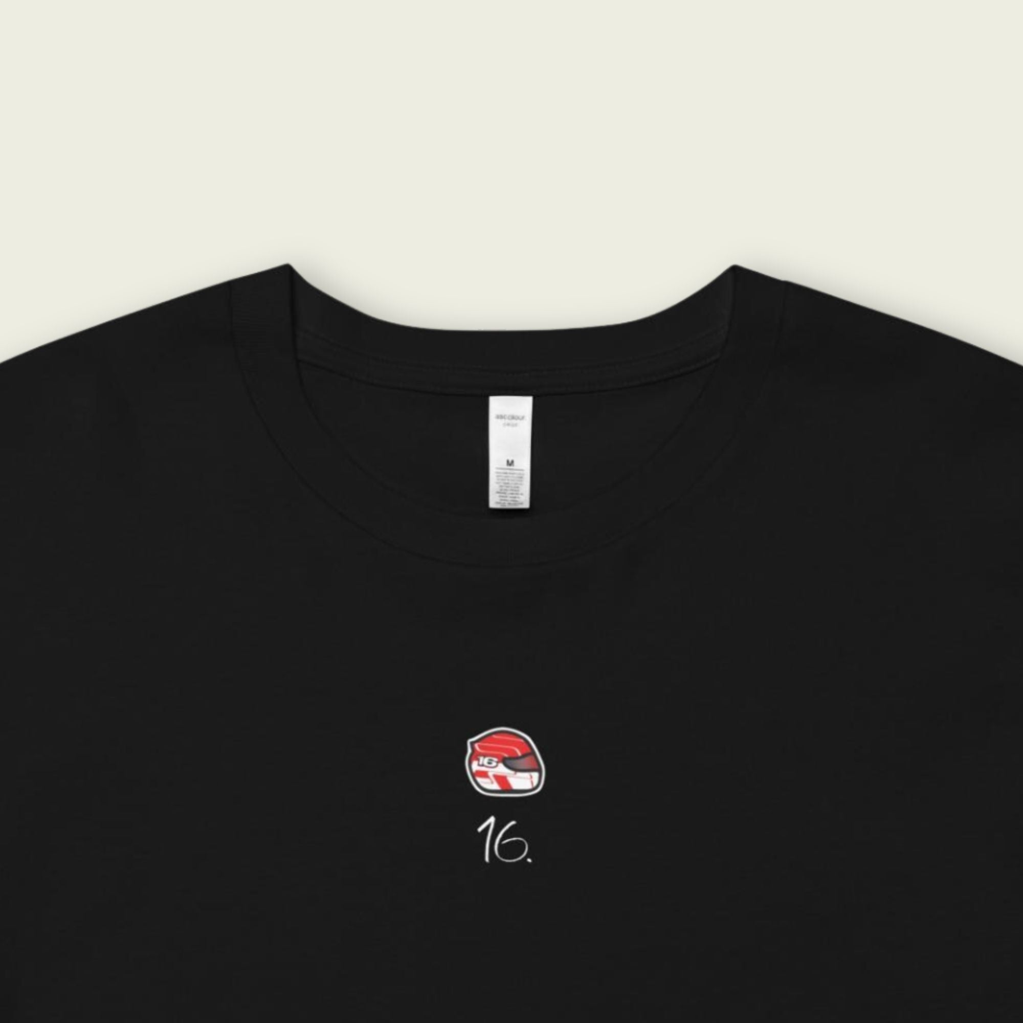 Black t-shirt with a small logo and number on a beige background