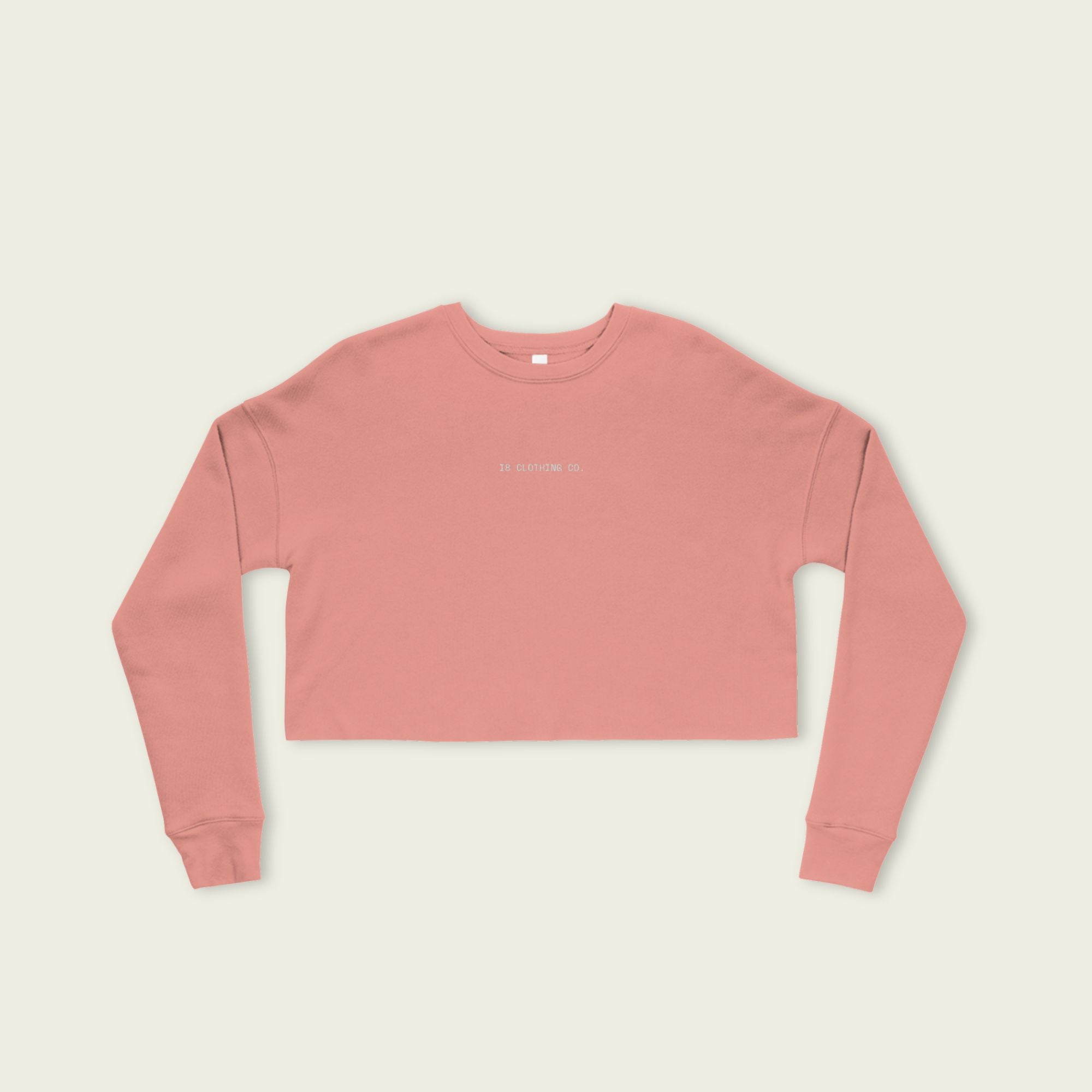 Pink long-sleeve crop top on a beige background