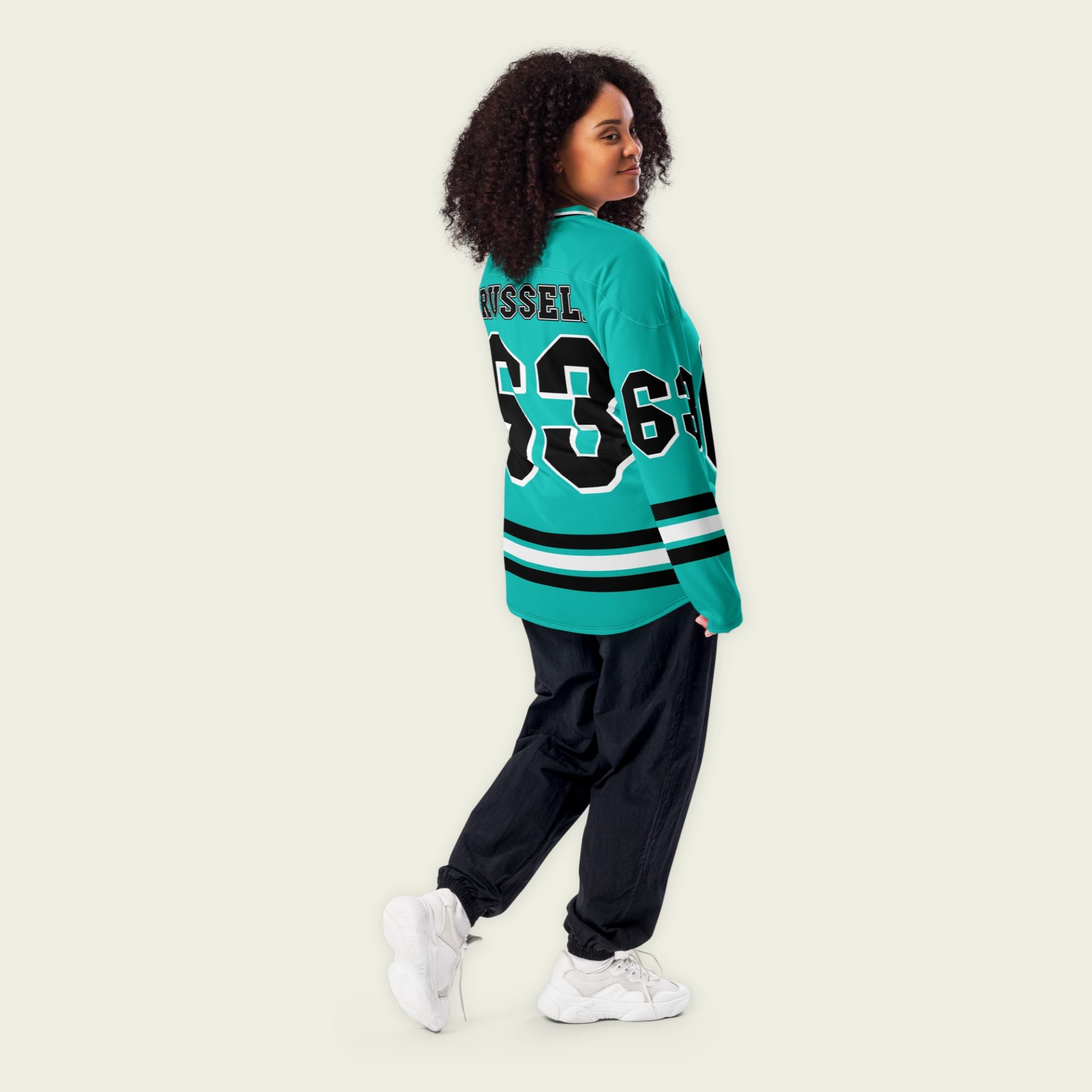 A green hockey jersey with three stipes on the bottom the middle one is white and the bottom and top are black. It has the number 63 that George Russell races with in F1 that is filled with black and a white outline, it is displayed on the back and front. Also there is text on the front and back "Russell"