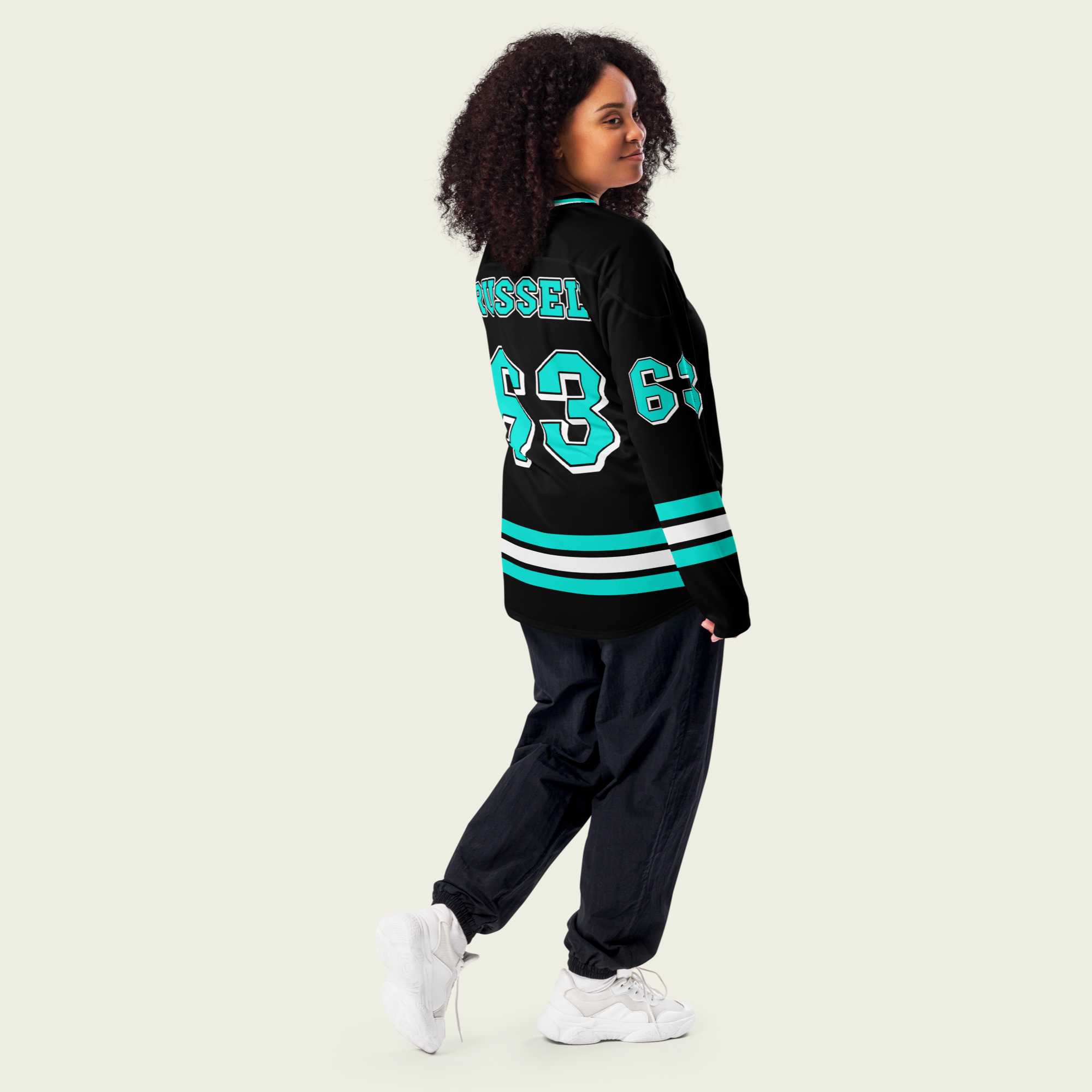 A black hockey jersey with george russells f1 racing number 63 on the front and back in mercedes green. His name Russell is on the front in back as well in turquoise.