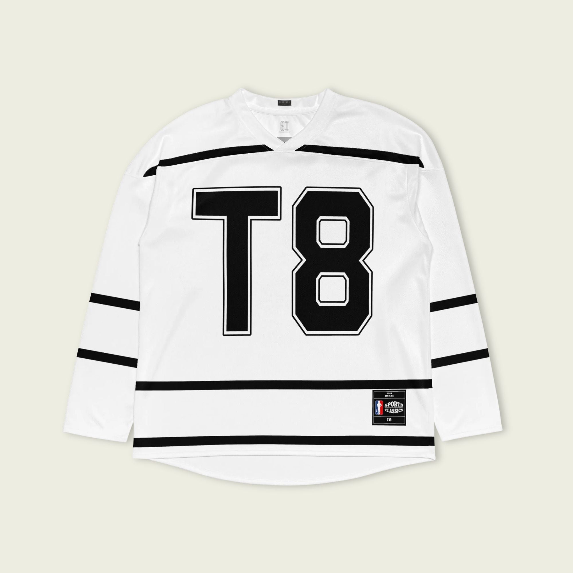 A Tate Mcrae white hockey jersey with black lines showing the name Mcrae in black on the back and T8 on the front.