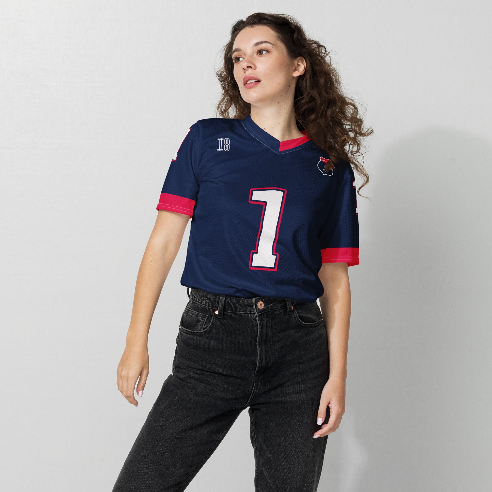 A navy blue and red football jersey with Max Verstappen's Redbull  F1 racing number 1 on the back and front in white. It has the name Verstappen in white on the front and back as well.