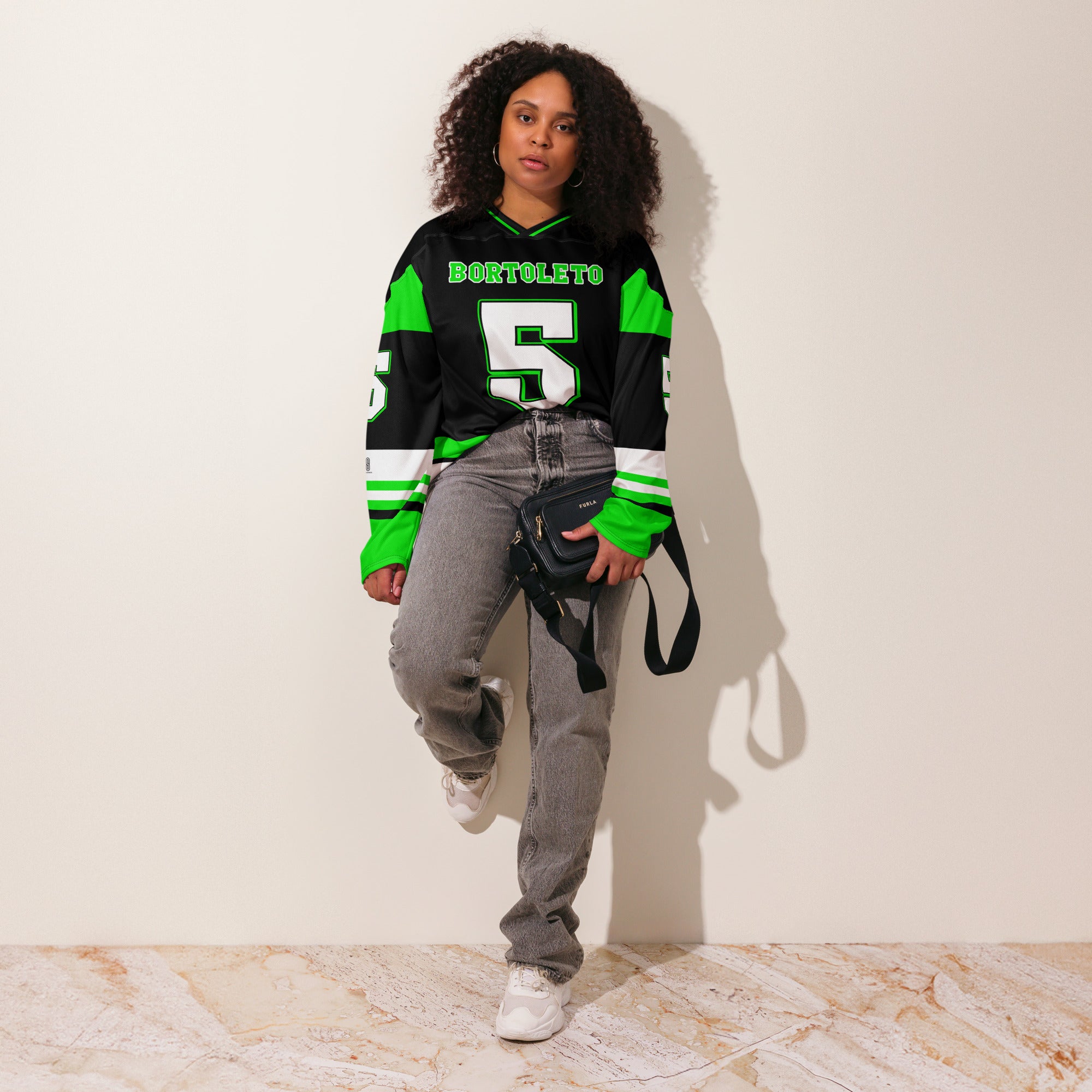 A green and black hockey jersey with Gabriel Bortoleto's Kick Stake F1 racing number 5 in green on the front and back. It has the name Gabriel Bortoleto on the back and front in green as well.