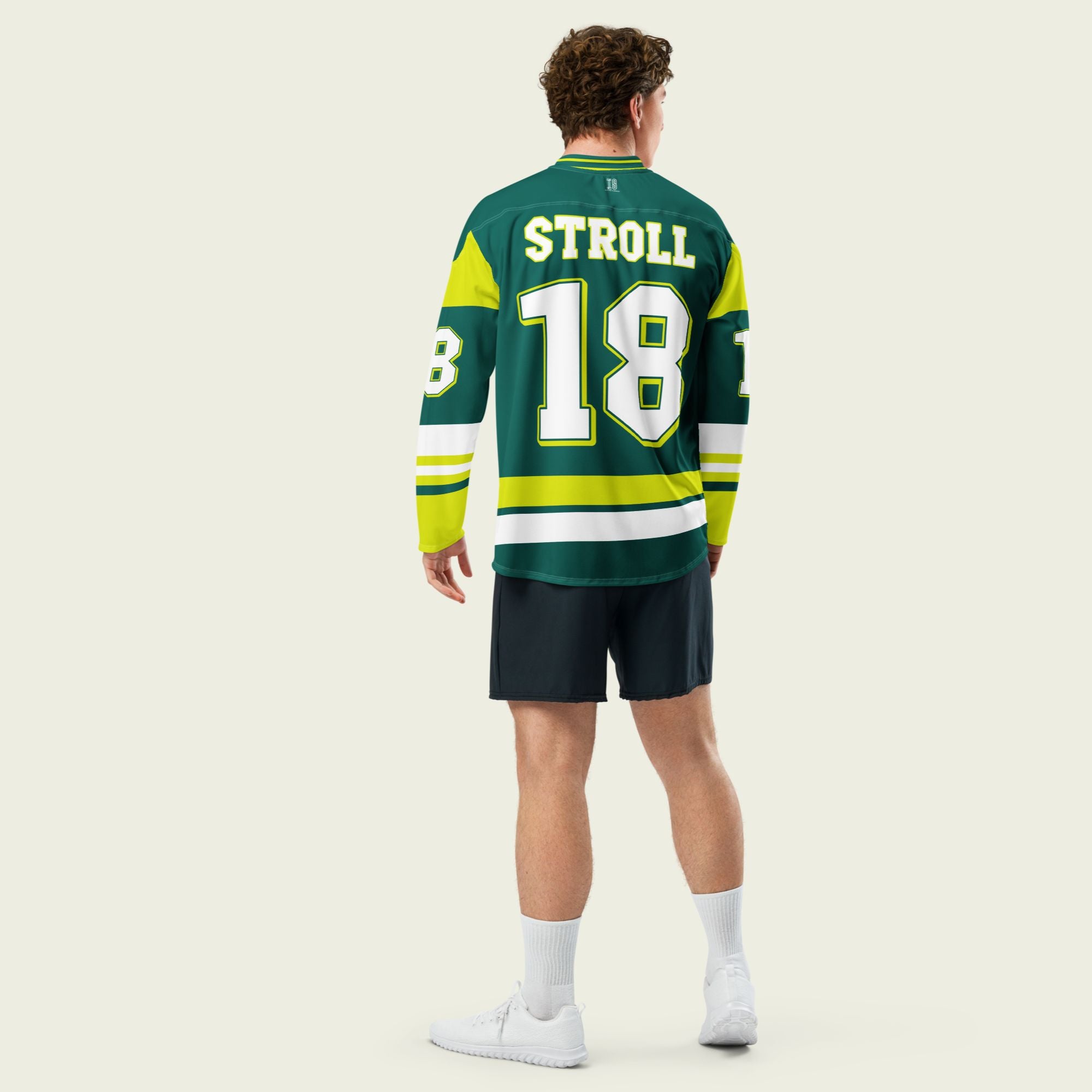 A british green hockey jersey with Lance Stroll's Aston Martin F1 racing number 18 in white on the front and back. It has the name Stroll on the back and front in white as well.