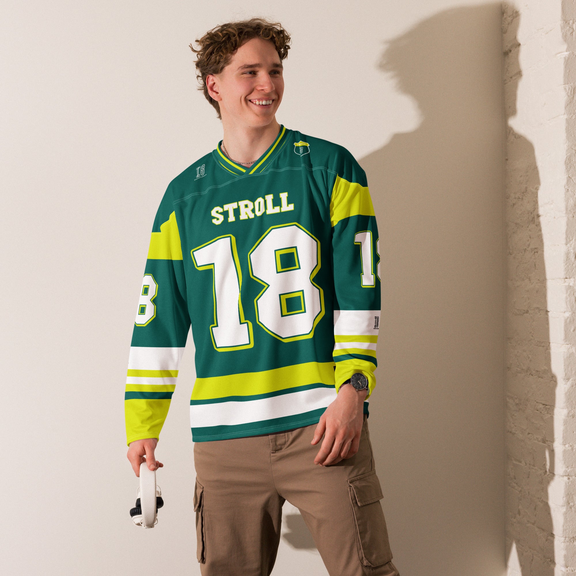 A british green hockey jersey with Lance Stroll's Aston Martin F1 racing number 18 in white on the front and back. It has the name Stroll on the back and front in white as well.