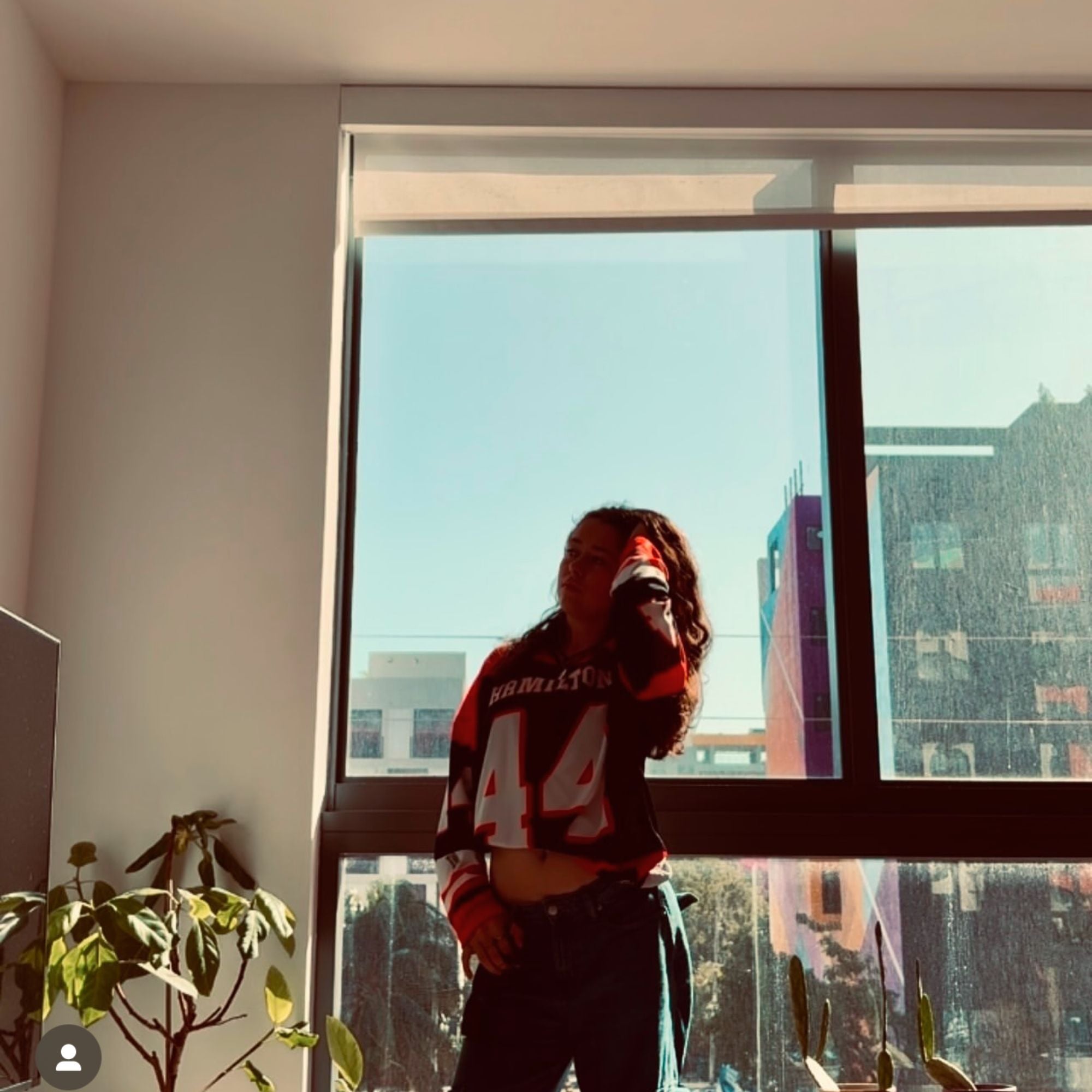 A red and black hockey jersey with Lewis Hamilton's F1 racing number 44 in white on the front and back. It has the name Hamilton on the back and front in white as well.
