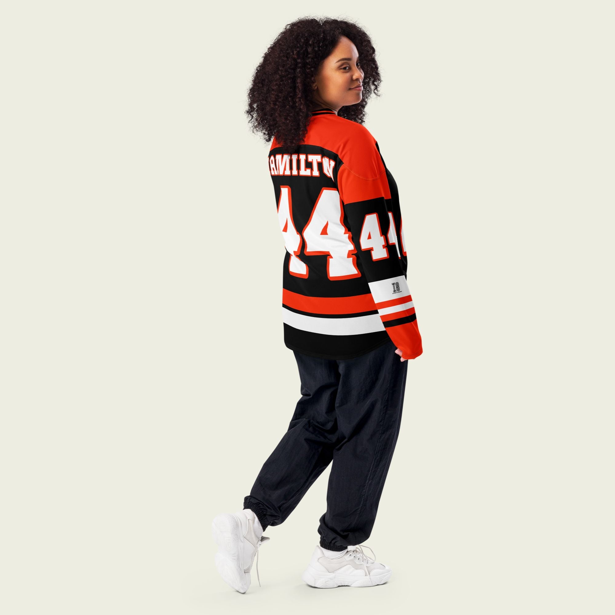 A red and black hockey jersey with Lewis Hamilton's F1 racing number 44 in white on the front and back. It has the name Hamilton on the back and front in white as well.