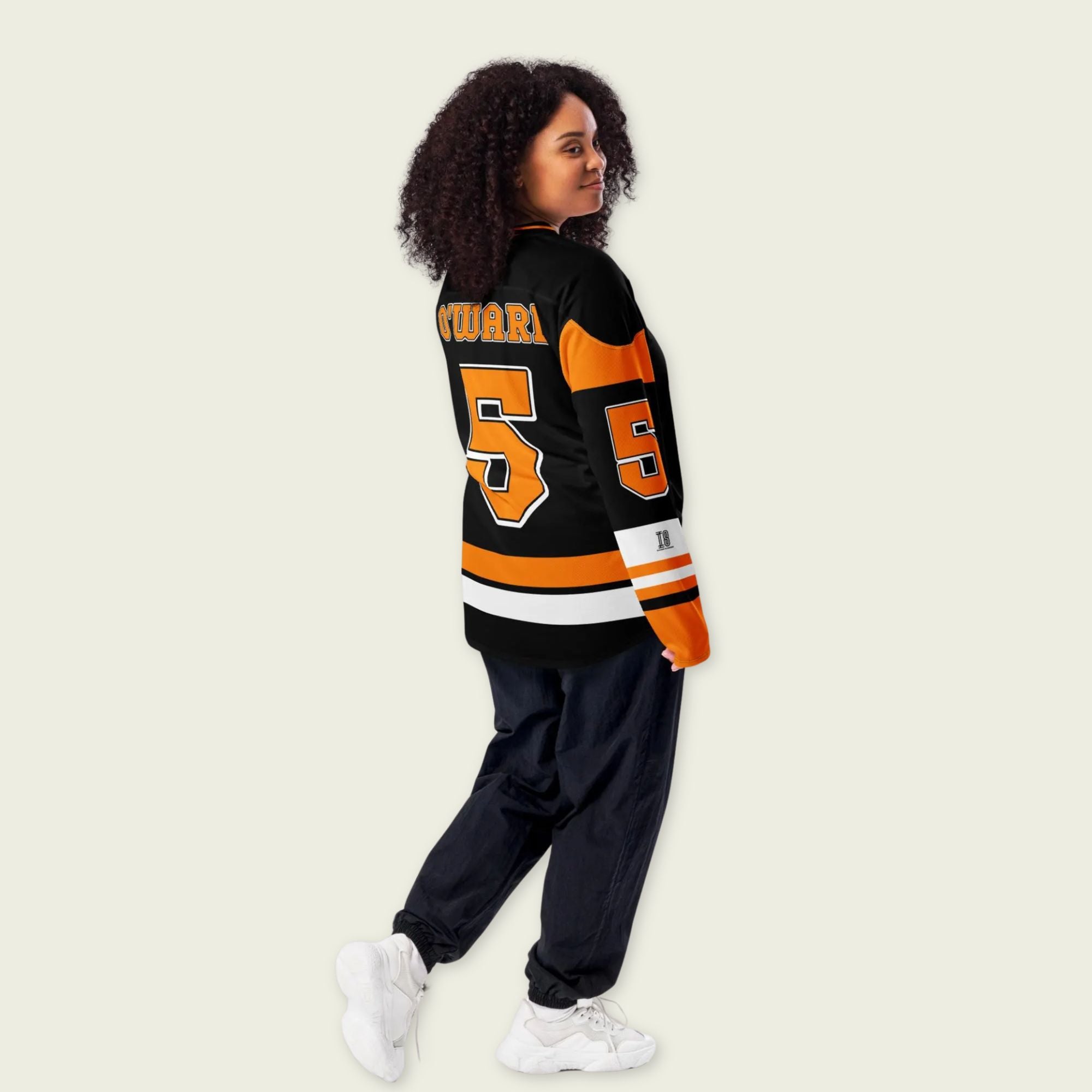 A black hockey jersey with Pato O'Ward's name and indycar racing number 5 on the front and back in orange.