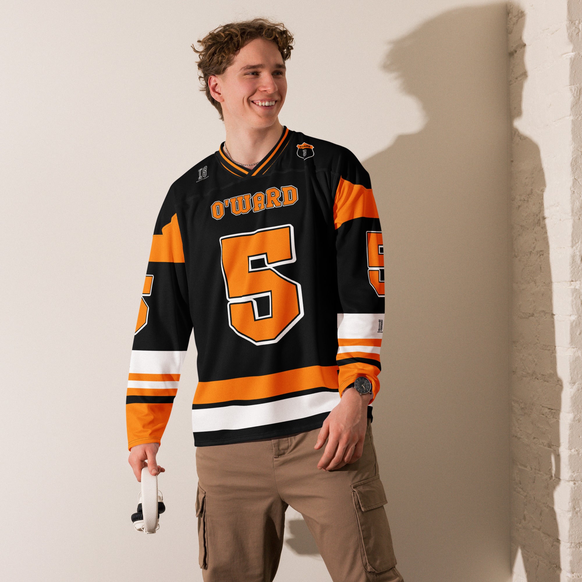 A black hockey jersey with Pato O'Ward's name and indycar racing number 5 on the front and back in orange.