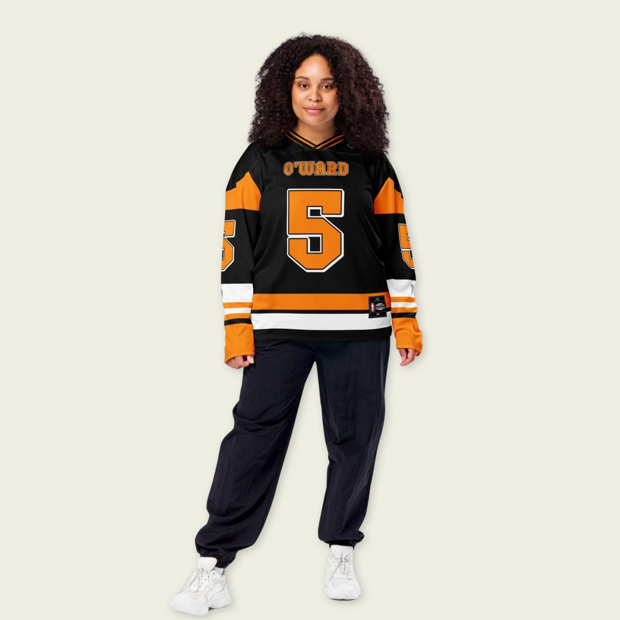 A black hockey jersey with Pato O'Ward's name and indycar racing number 5 on the front and back in orange.