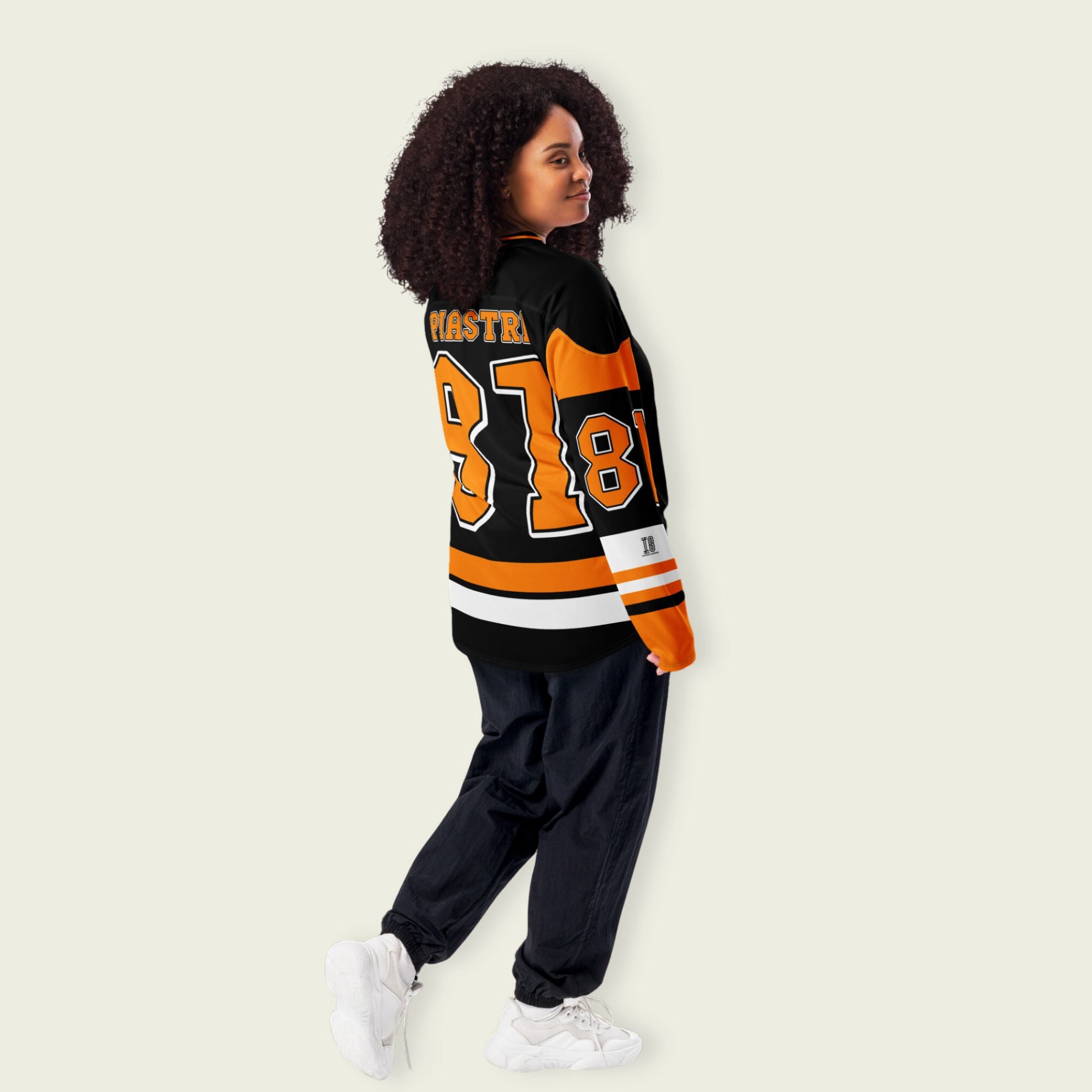 A black hockey jersey with Osacr Piastri's mclaren F1 racing number 81 on the front and back in papaya orange, also the name norris is on the back and front in orange