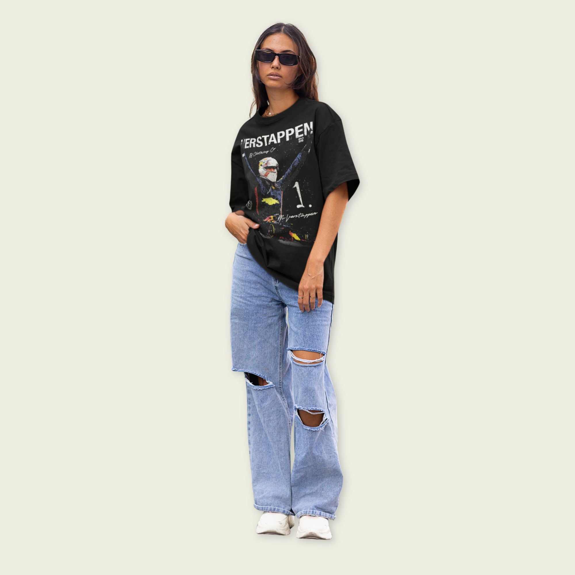 Person wearing a black graphic t-shirt and ripped jeans on a light background