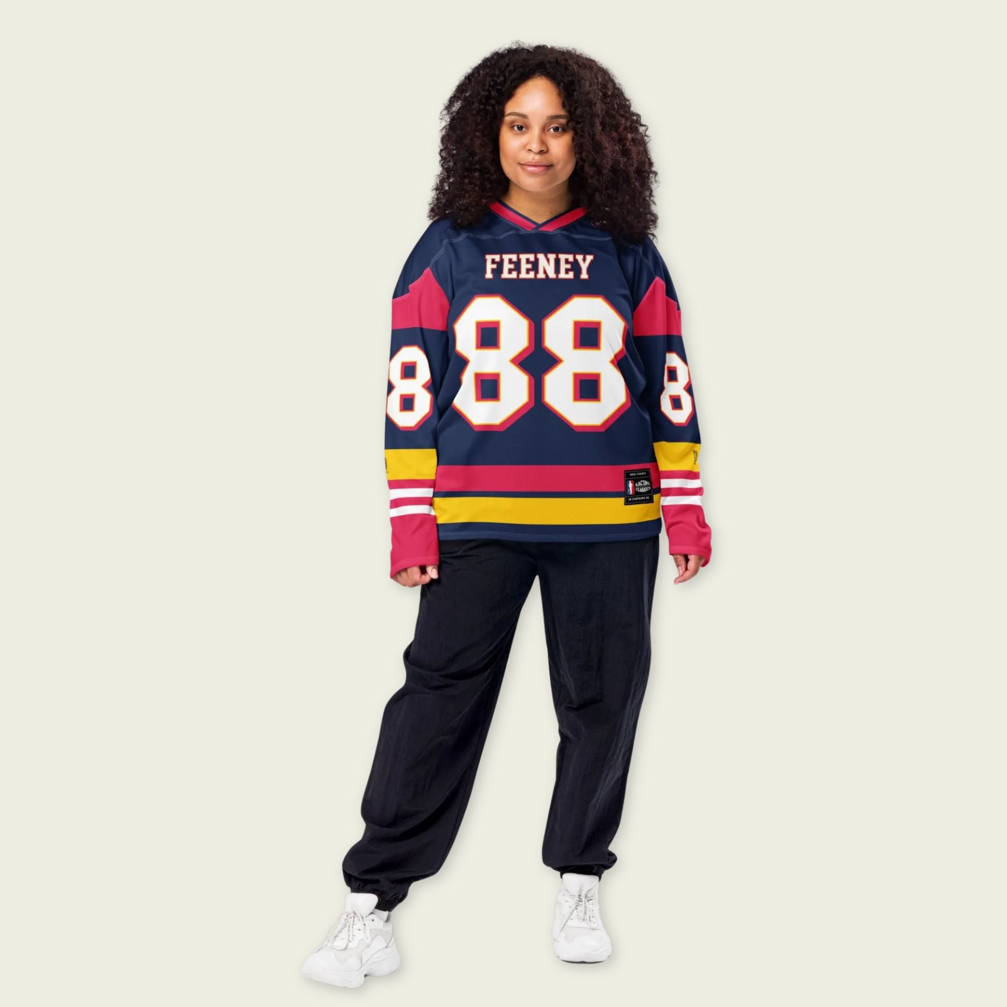 Person wearing a colorful sweater with 'FEENEY 88' text on a beige background