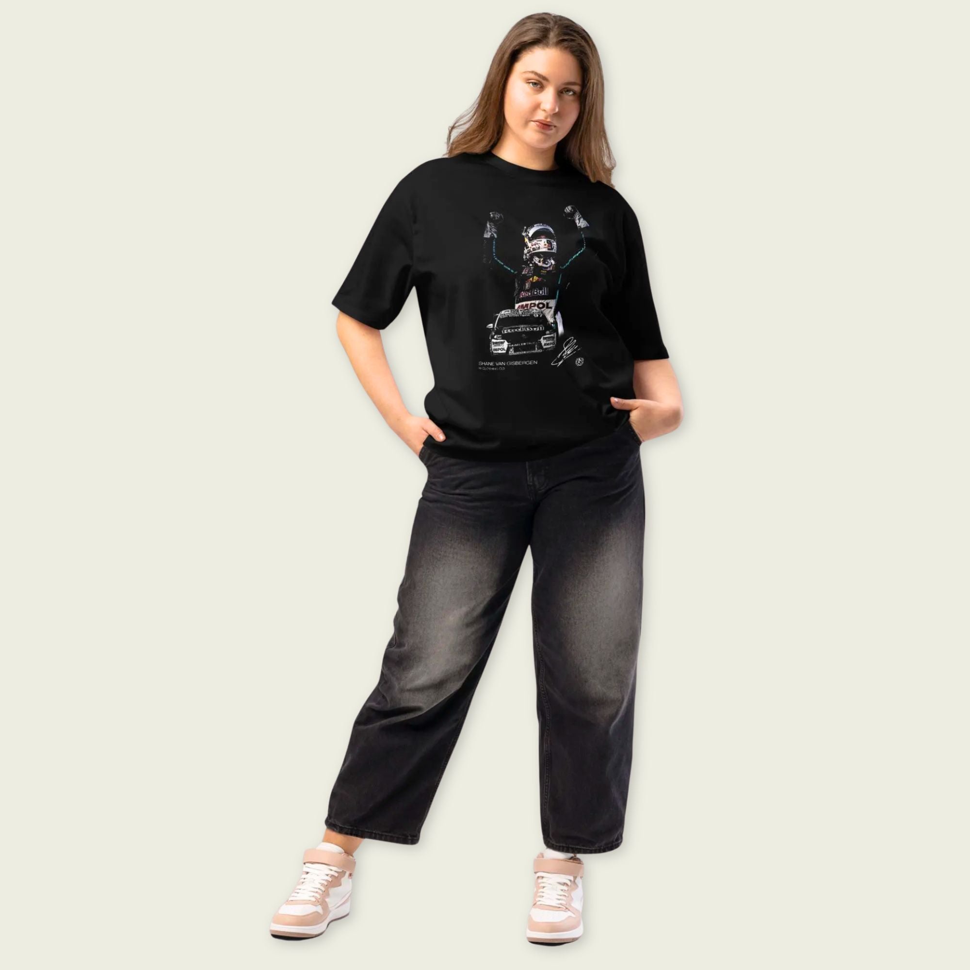 Woman wearing a black t-shirt with a graphic design on a plain background