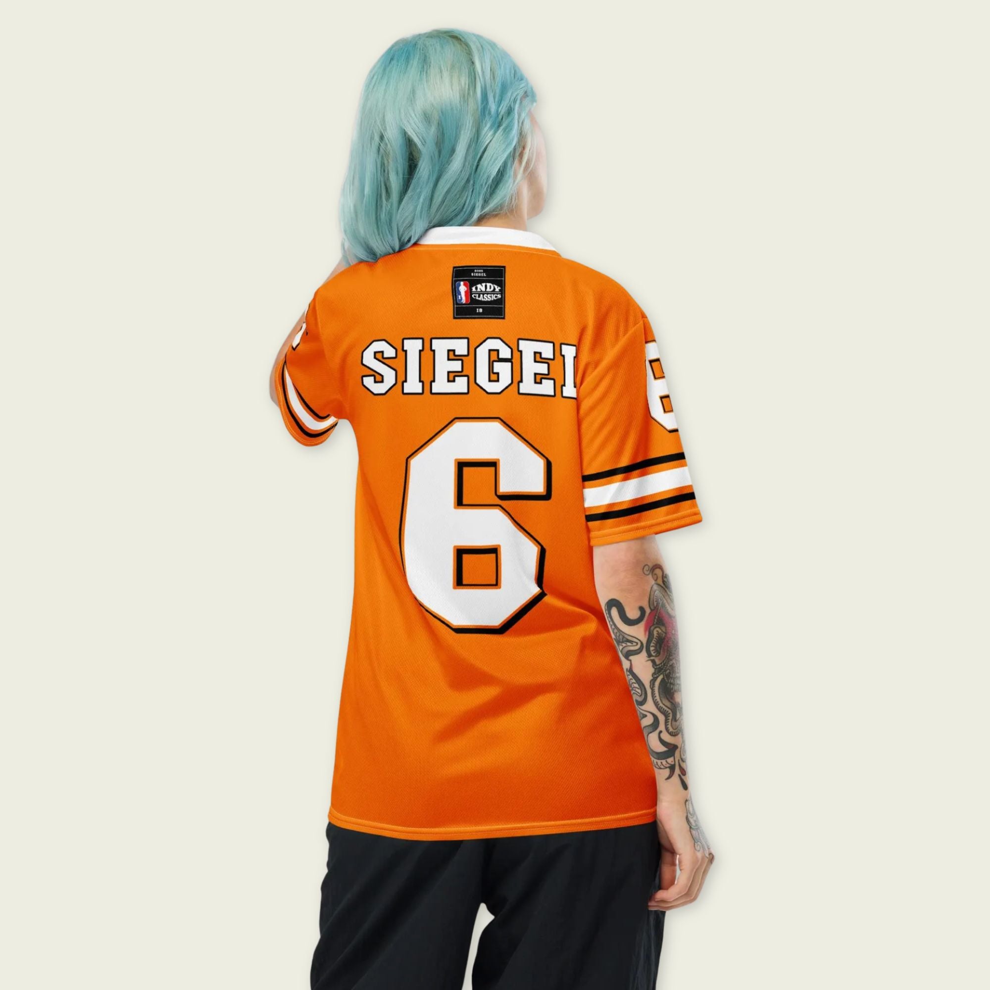 Person wearing an orange sports jersey with 'SIEGE!' and number '6' on a plain background