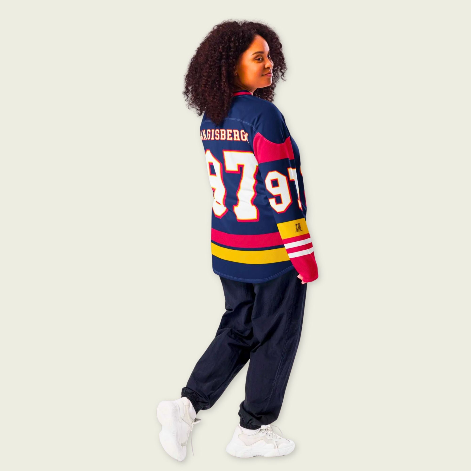 Person wearing a colorful sports jersey with numbers on a plain background
