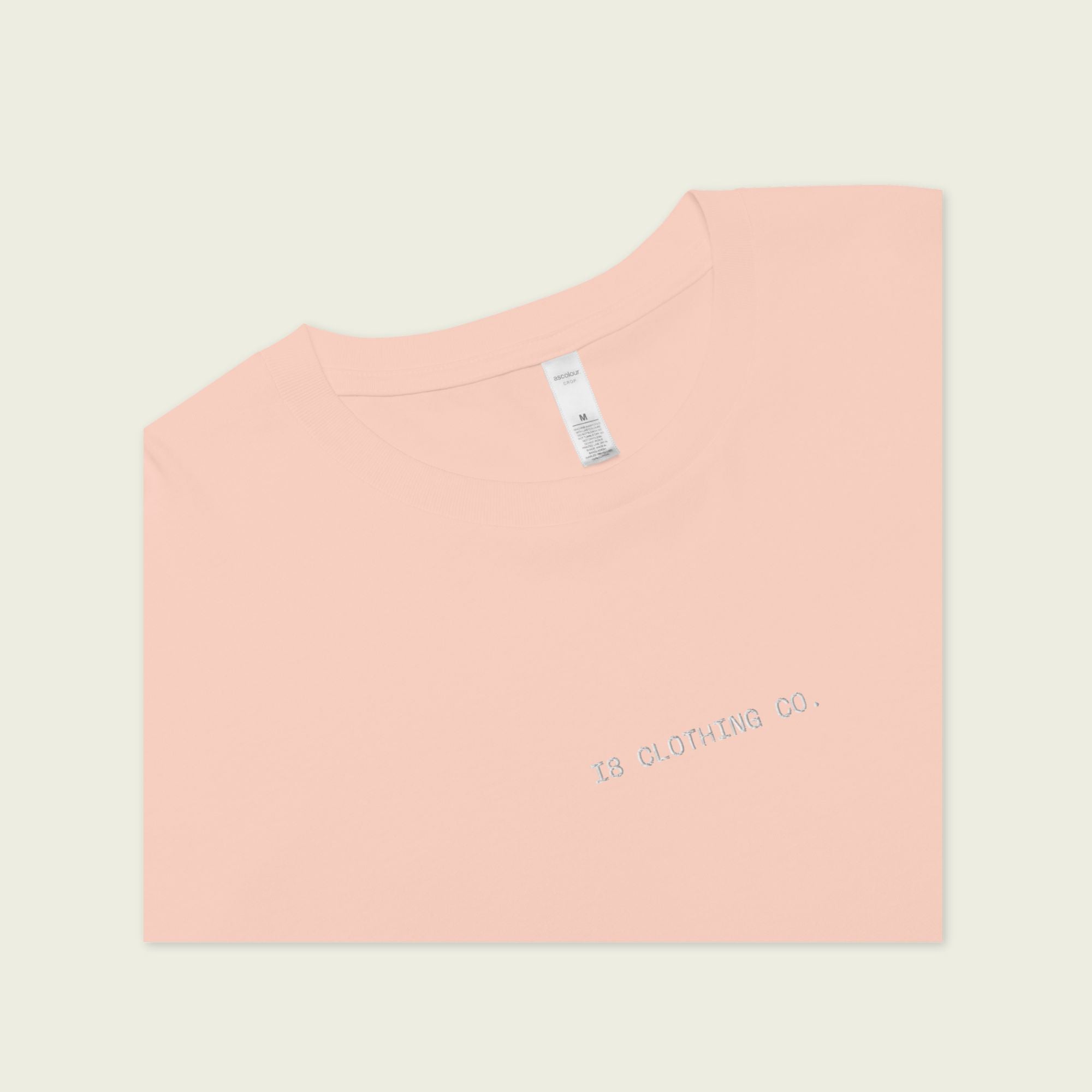 Pink t-shirt with text on a light beige background
