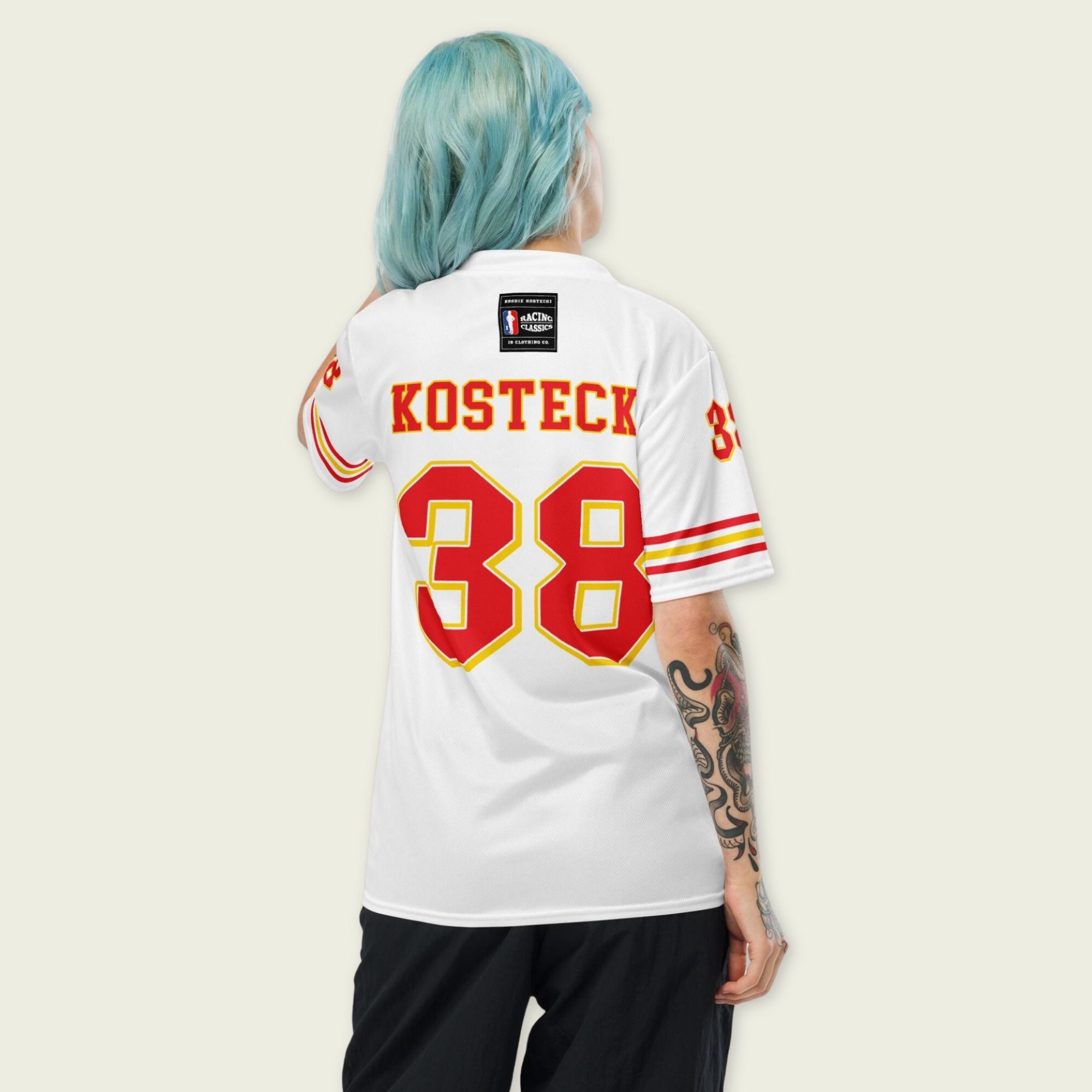 Person wearing a white sports jersey with red and yellow details, featuring the name 'Kosteck' and number '38'.