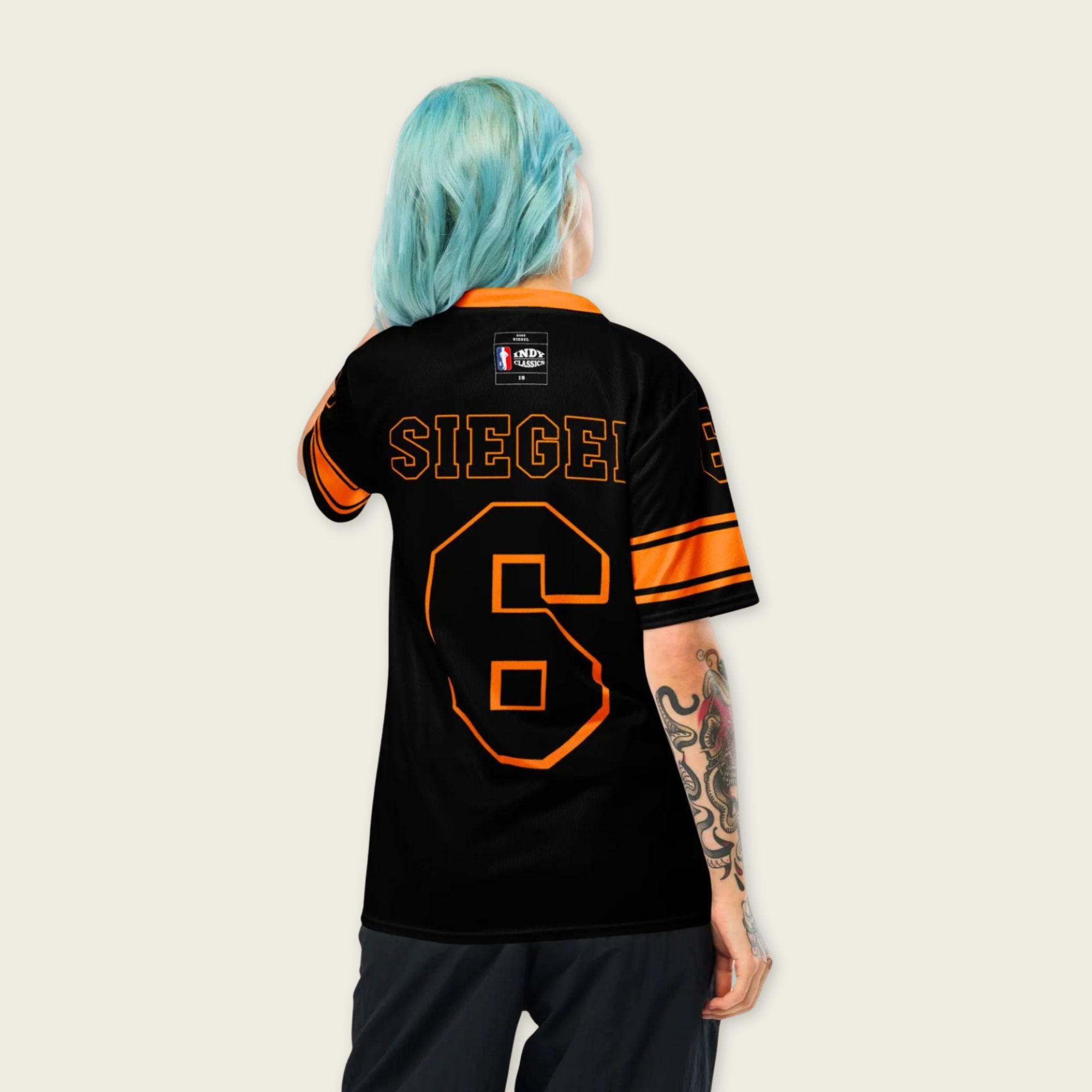 Person wearing a black sports jersey with orange lettering and numbers on a plain background