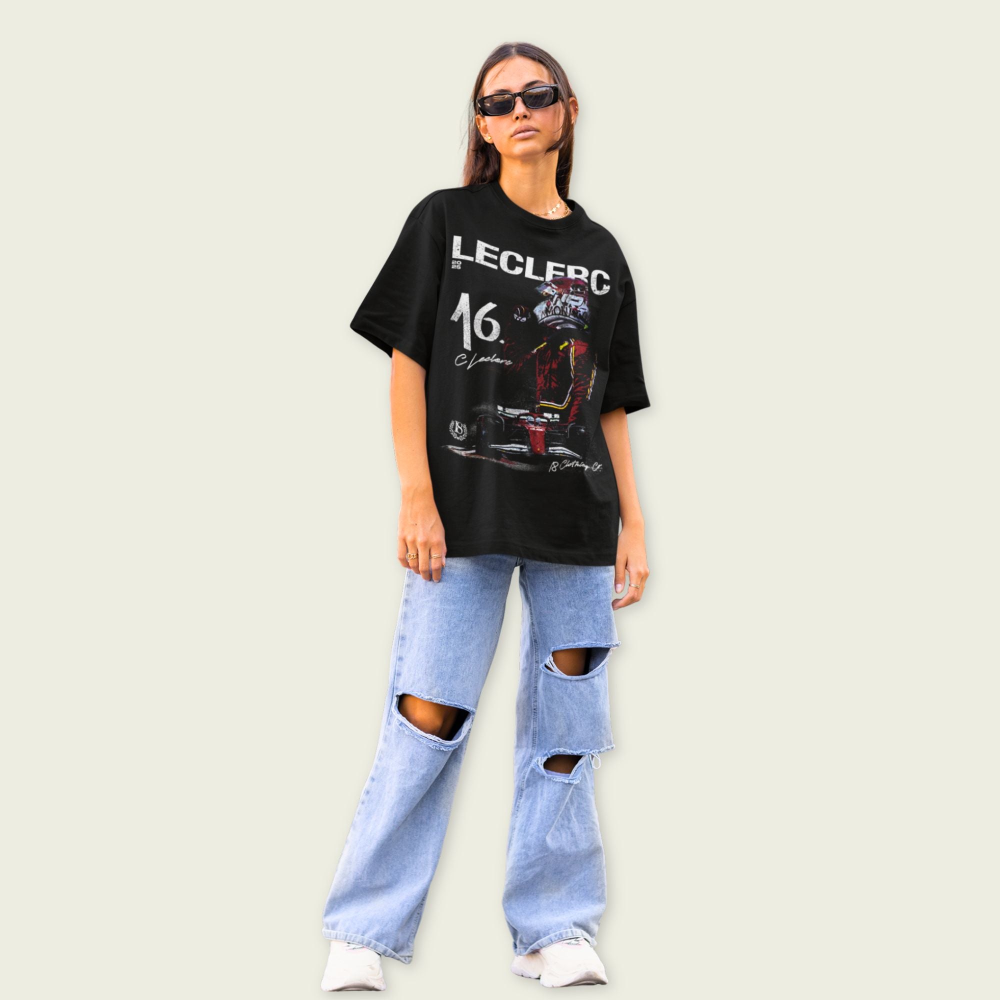 Person wearing a black graphic t-shirt and ripped jeans on a plain background