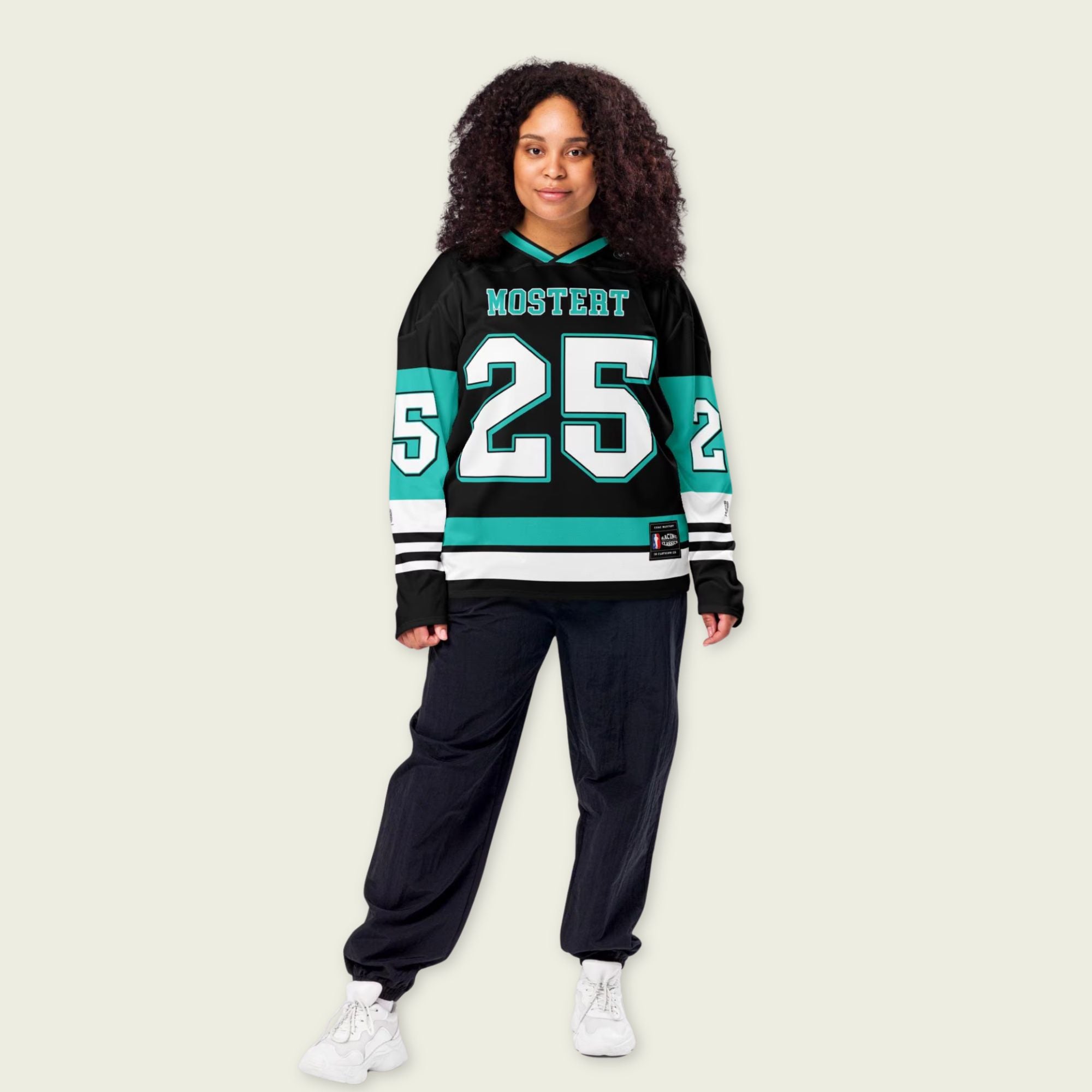 Person wearing a black sports jersey with numbers and letters on a beige background
