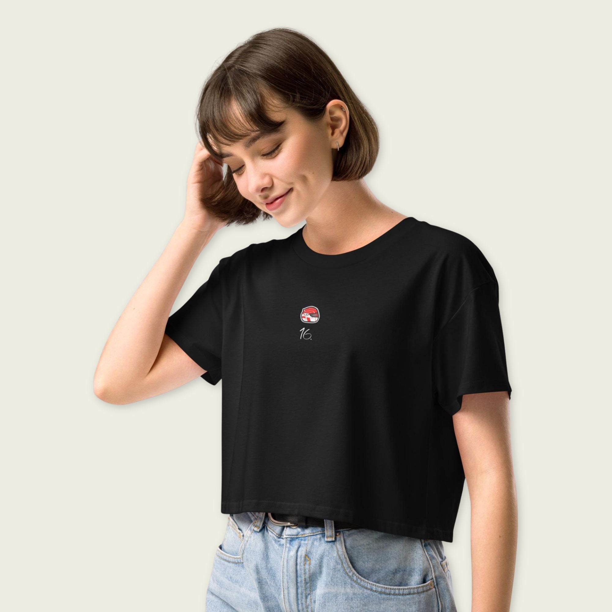 Person wearing a black t-shirt with a small graphic on a plain background